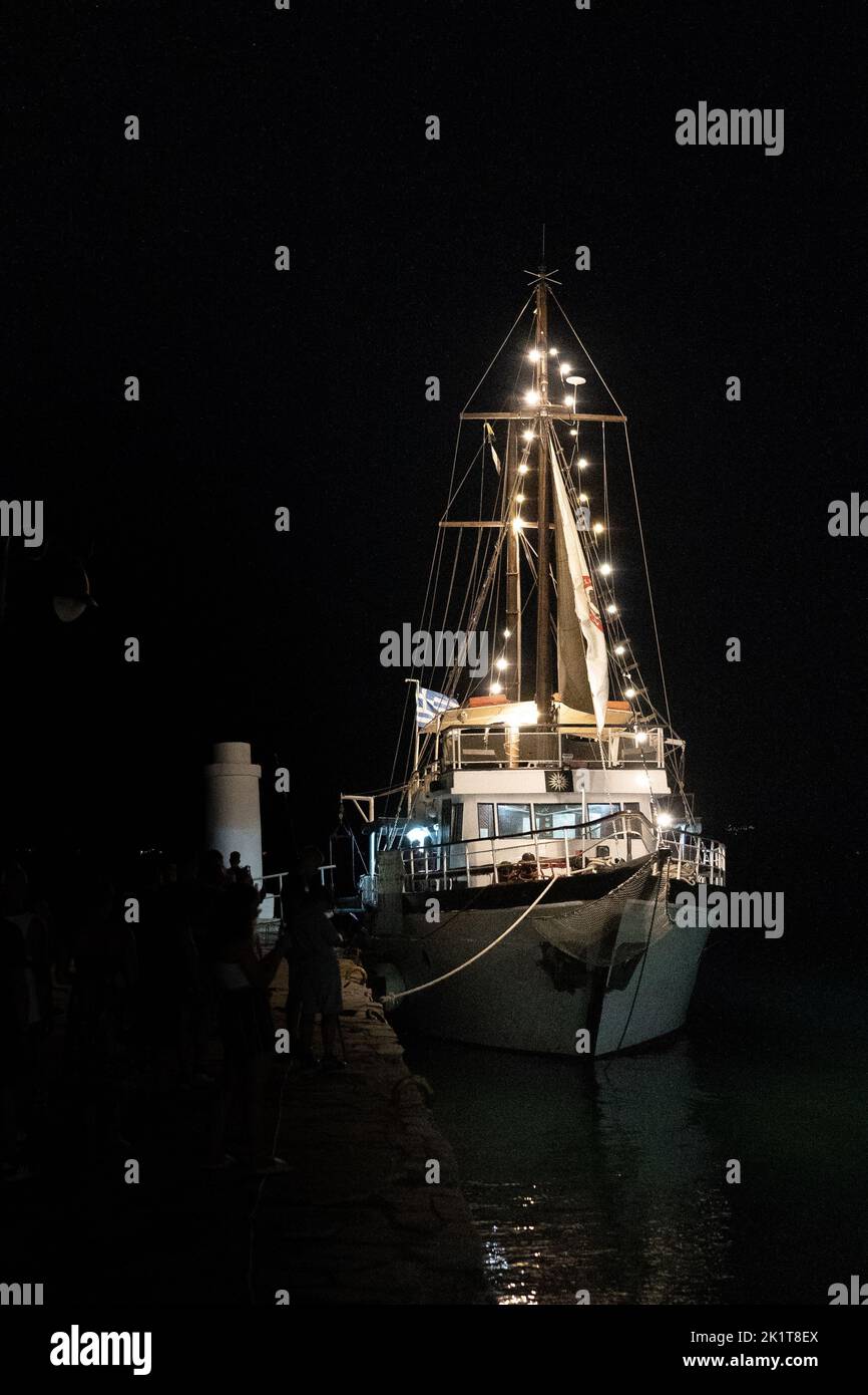 Una barca illuminata ormeggiata al molo Foto Stock