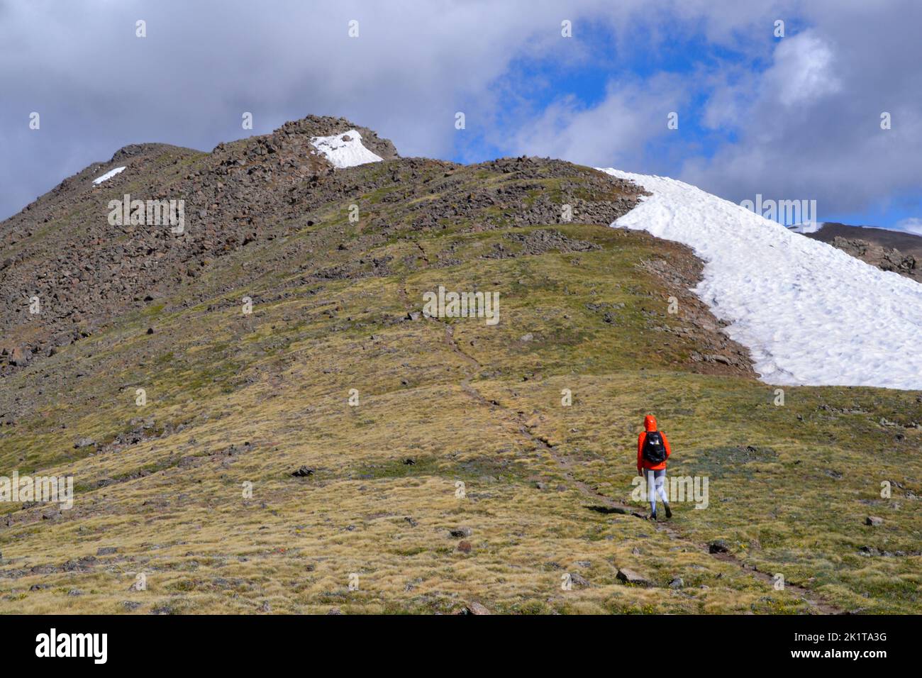 Una persona con un piccolo daypack segue un sentiero fino alla cima del monte Elbert, la vetta più alta del Colorado USA Foto Stock