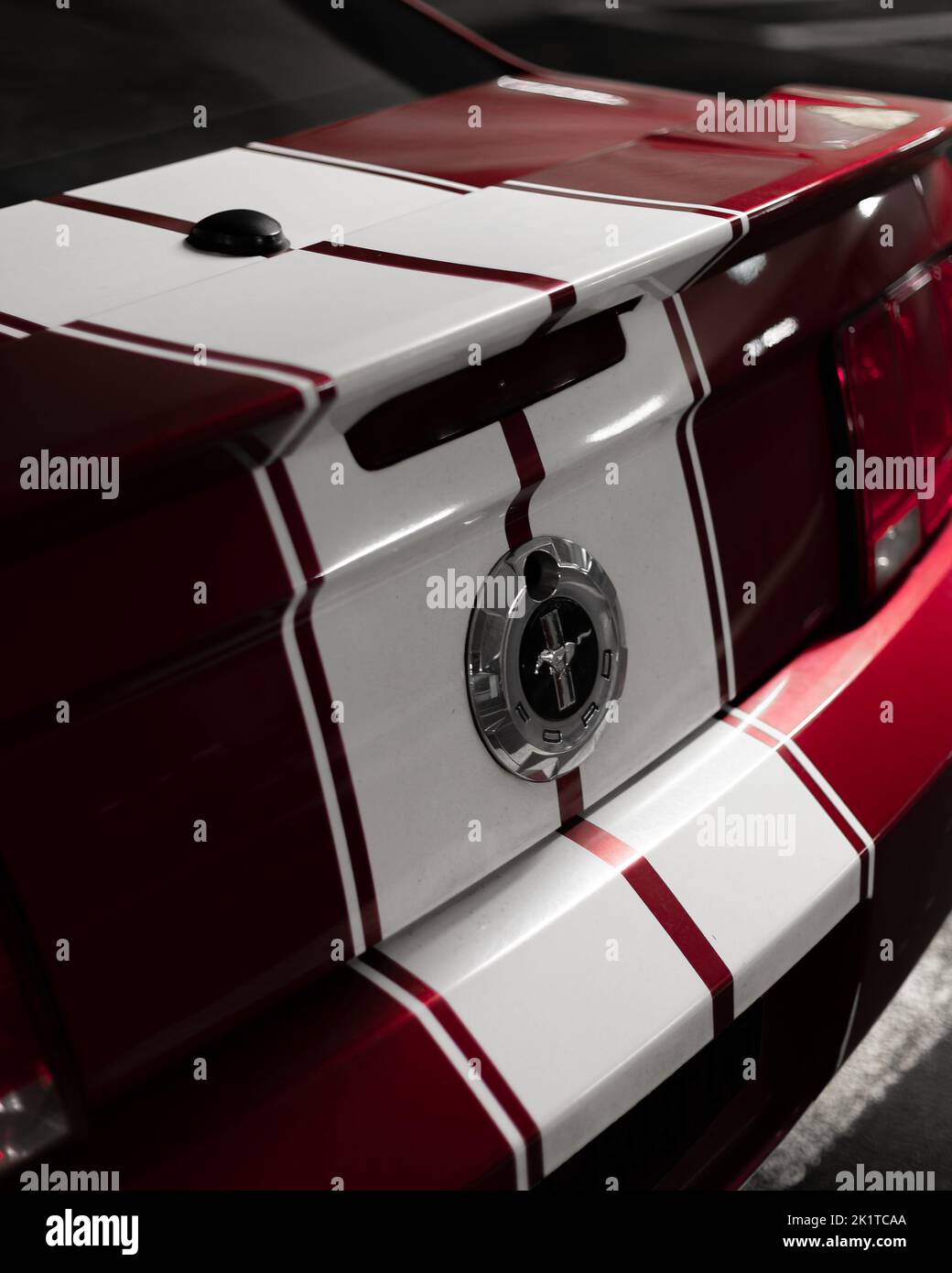 Un primo piano verticale di un Mustang Ford Rosso con strisce bianche Foto Stock