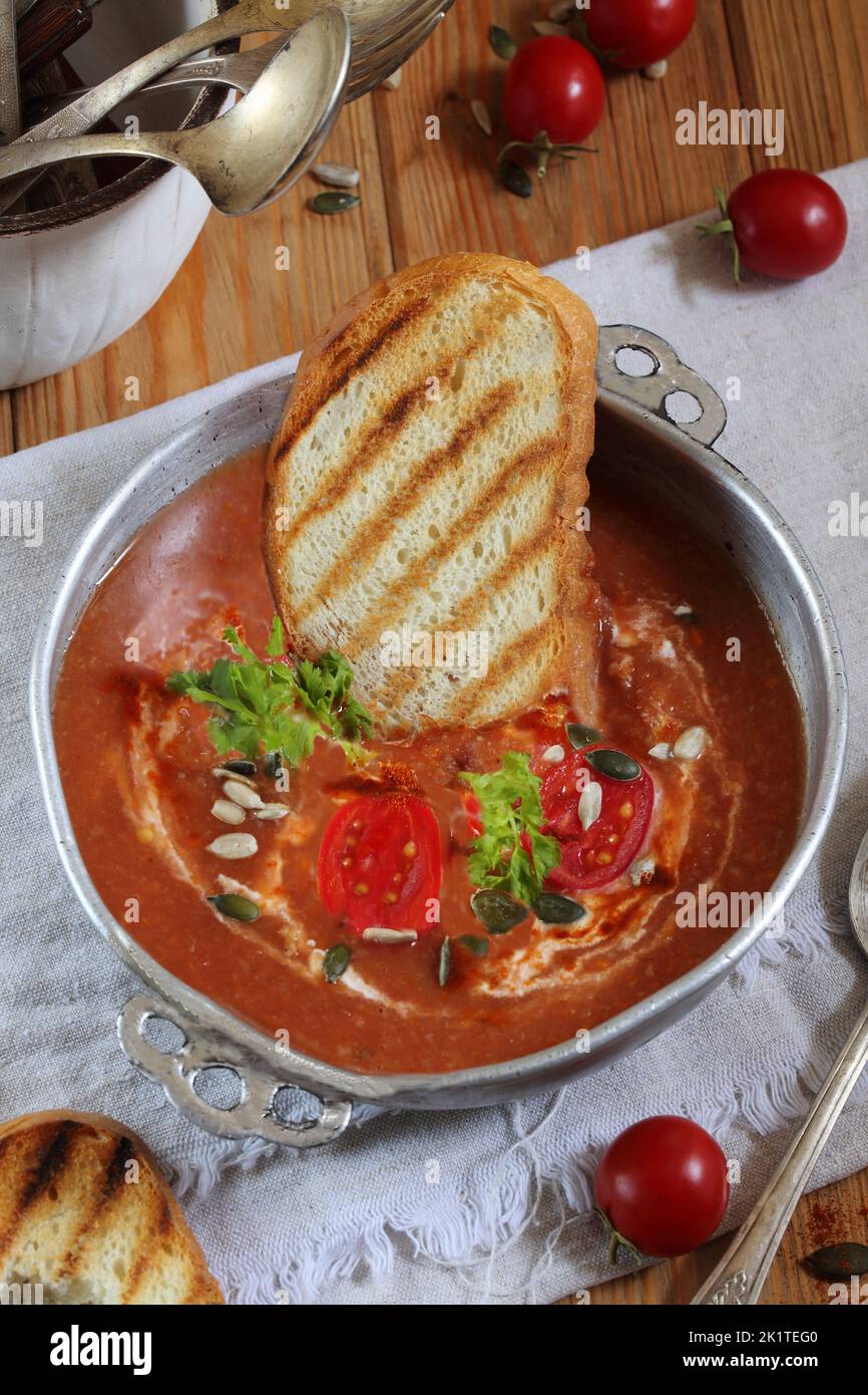 Zuppa di Gaspacho su sfondo di legno con pane tostato Foto Stock