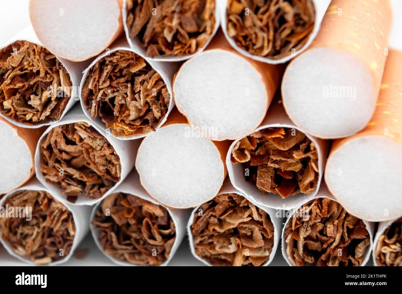 Immagine full frame di primo piano su una pila di molte sigarette accatastate concetto per problemi di salute a causa del fumo di sigaretta, pericoloso stile di vita sfondo Foto Stock