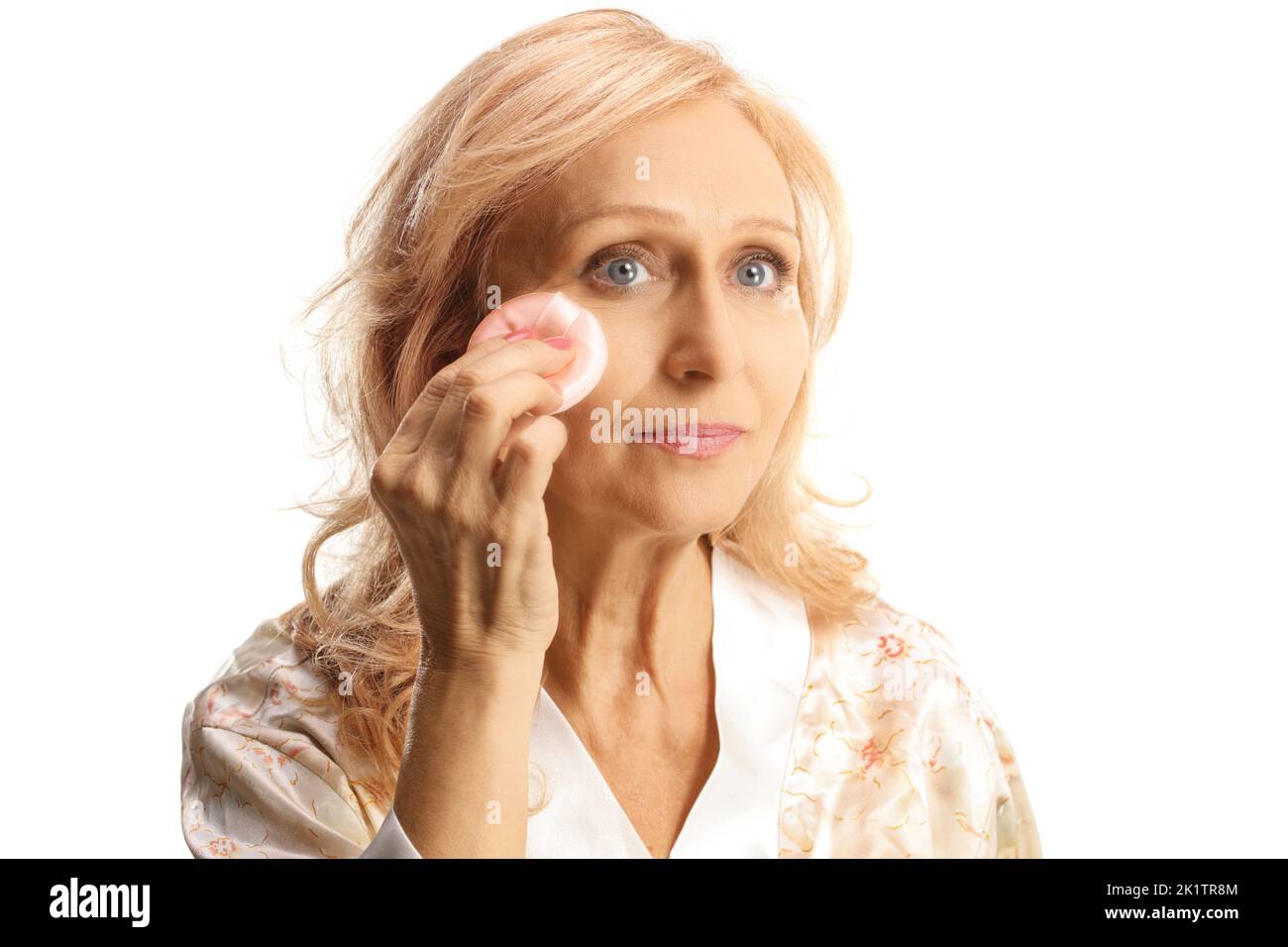 Donna matura che rimuove il make up con un tampone di cotone isolato su sfondo bianco Foto Stock