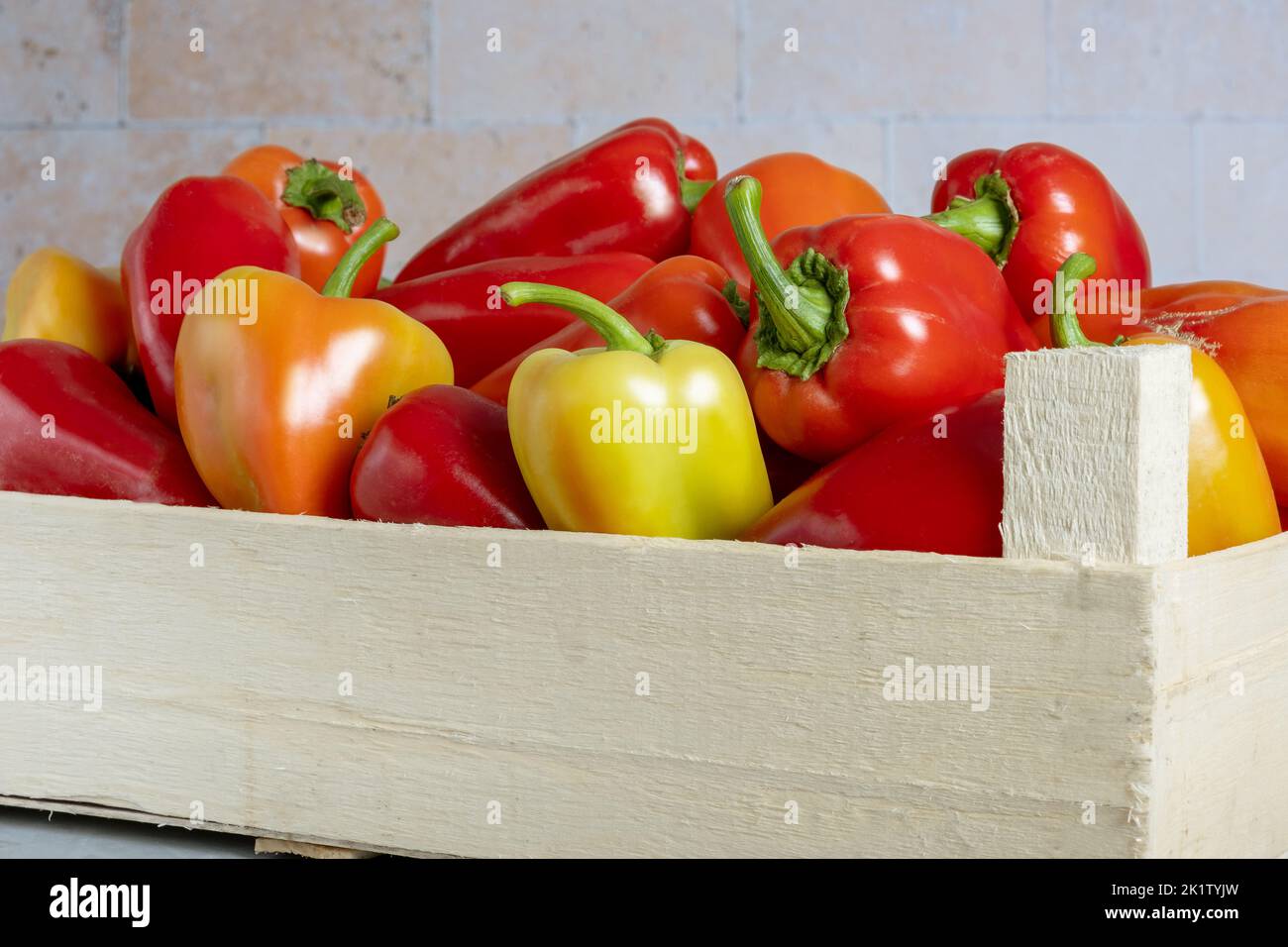 Scatola di legno con peperoni maturi. Foto Stock