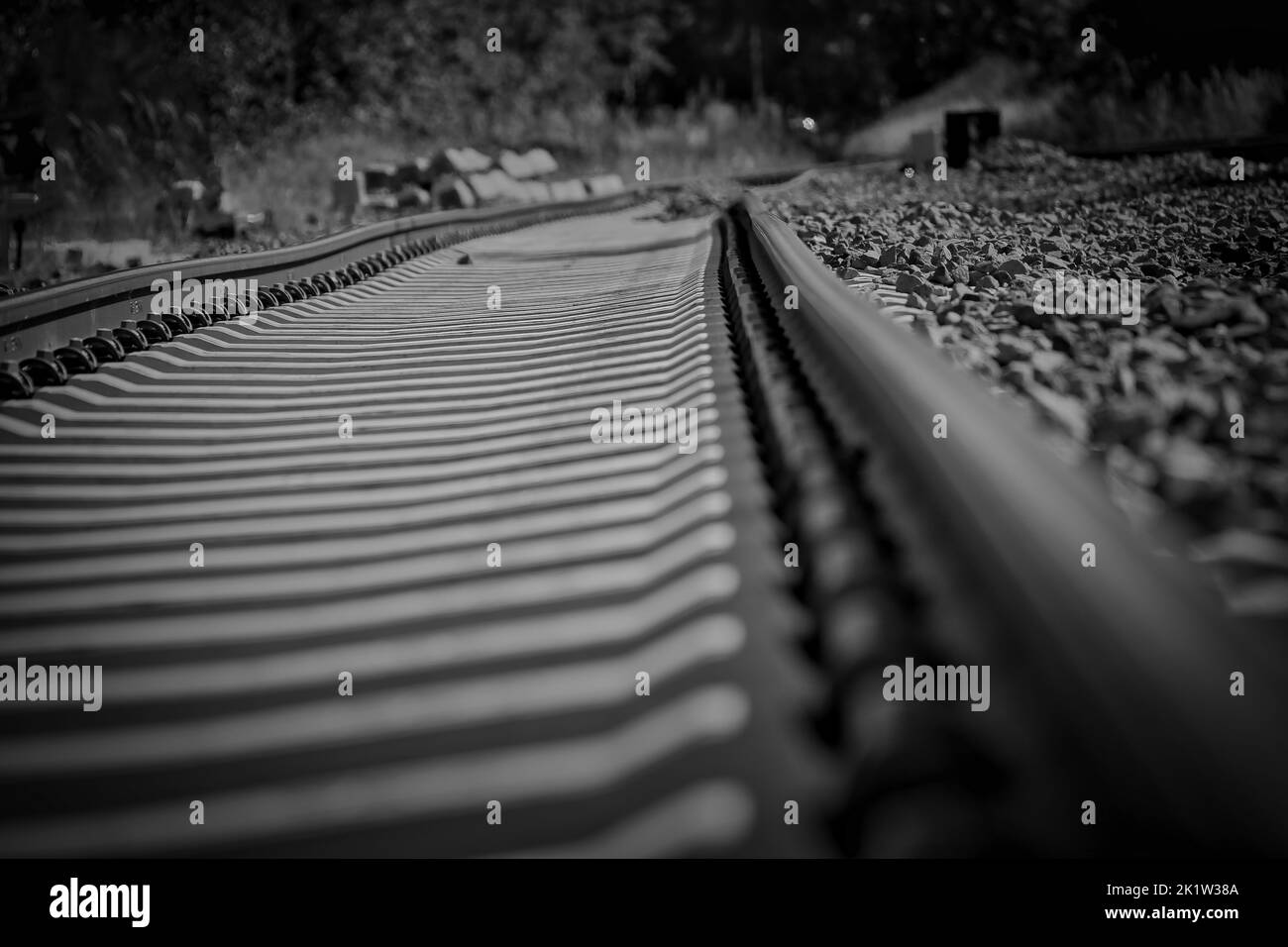 Un'immagine in scala di grigi di una linea ferroviaria vuota Foto Stock