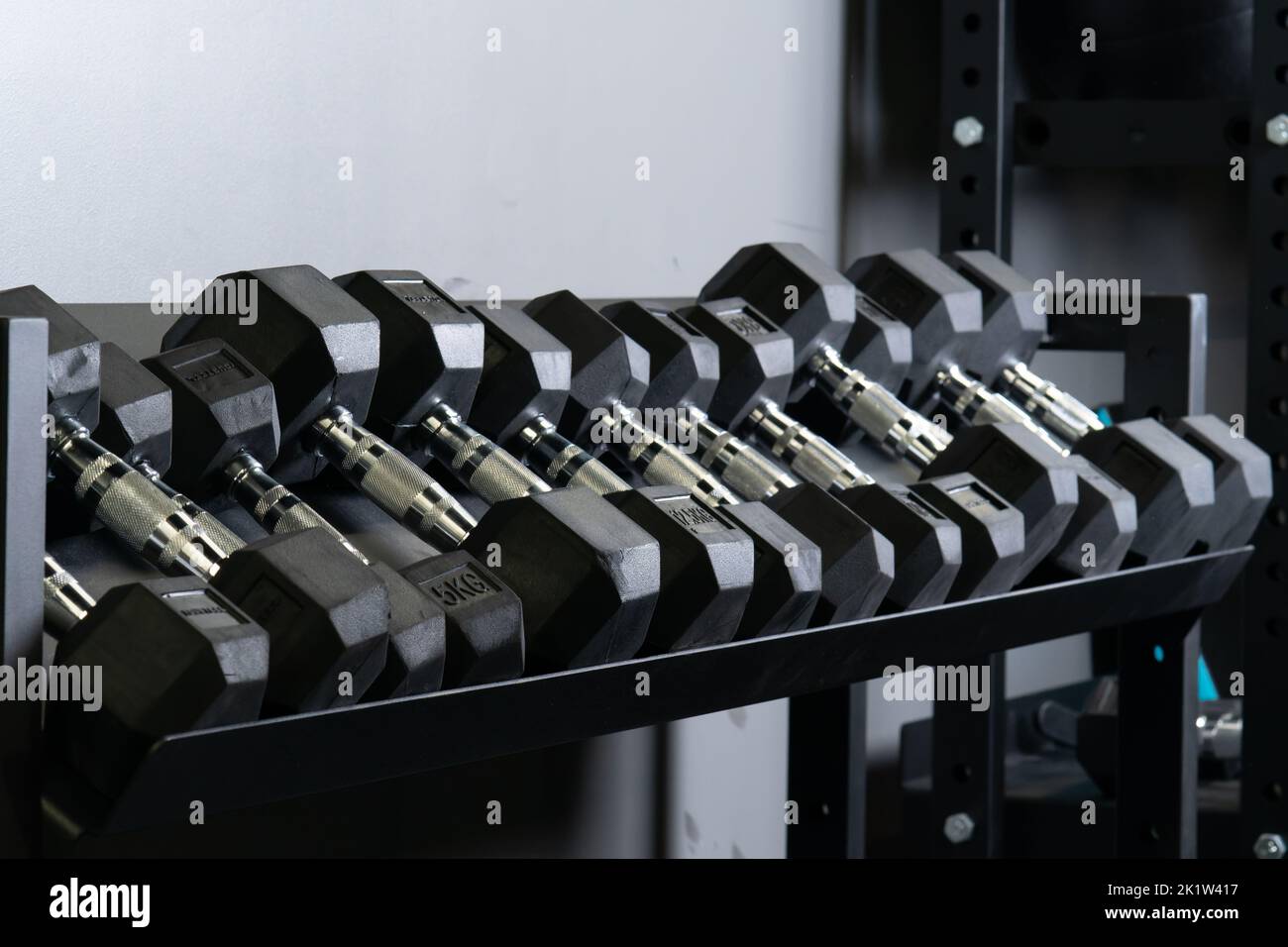 Dumbbell palestra parete blurry casa set attrezzatura di stoccaggio, per gli accessori presa per la mano nera e muscolare, potenza difficile. , Foto Stock