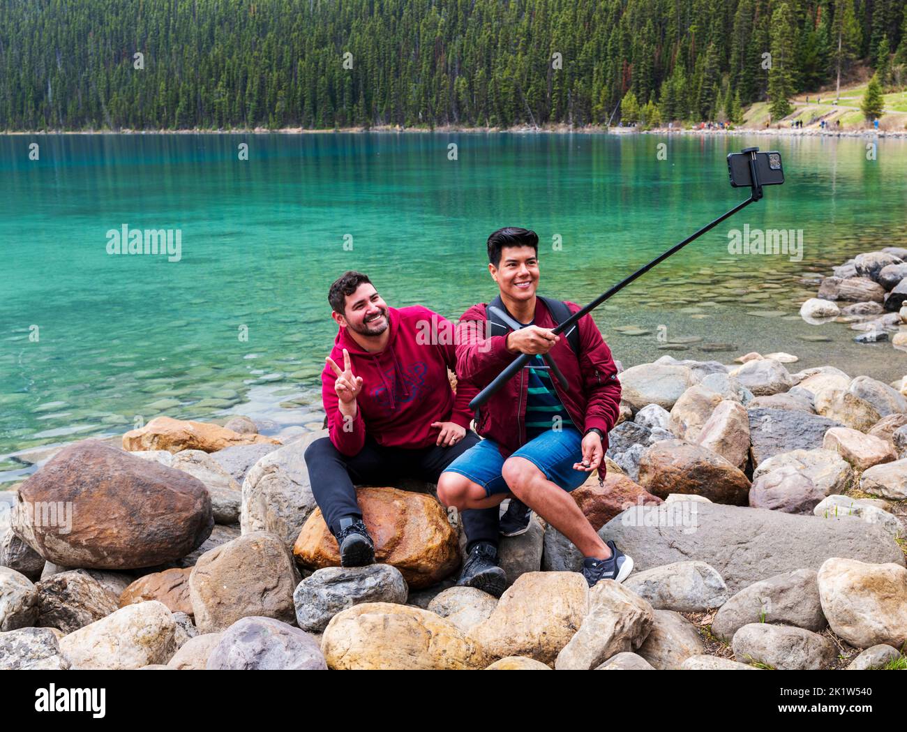 Due visitatori stranieri adulti maschi scattano una foto al selfie; Lake Louise; Banff National Park; Alberta; Canada Foto Stock