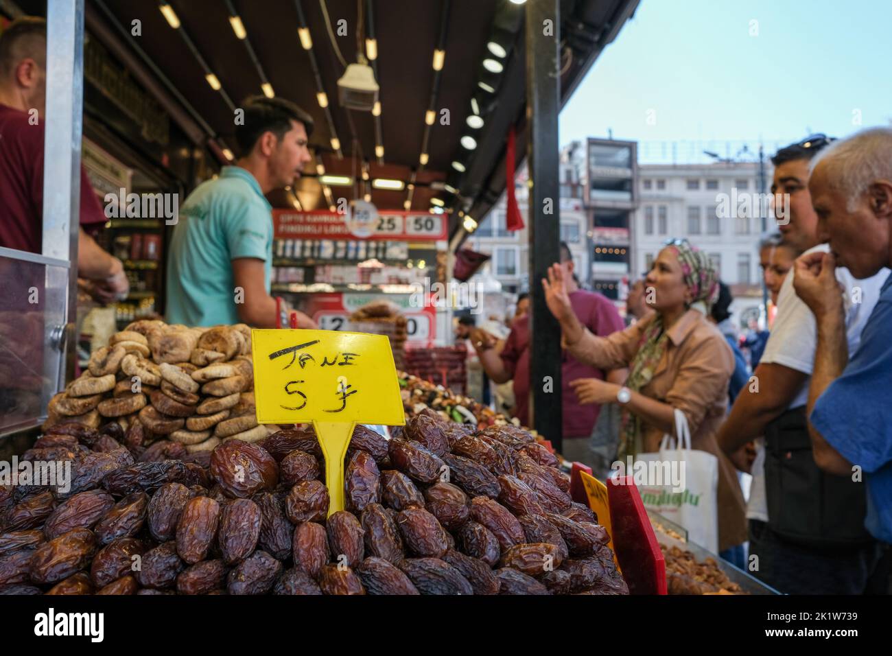 I dipendenti che vendono frutta secca e noci offrono ai loro clienti delizie. Situato nel quartiere Eminönü di Istanbul, lo storico Bazaar delle spezie continua ad essere un centro commerciale preferito dai turisti locali e stranieri. E' un luogo distinto dove turisti da tutto il mondo possono fare acquisti e gustare prelibatezze specifiche del paese. Foto Stock