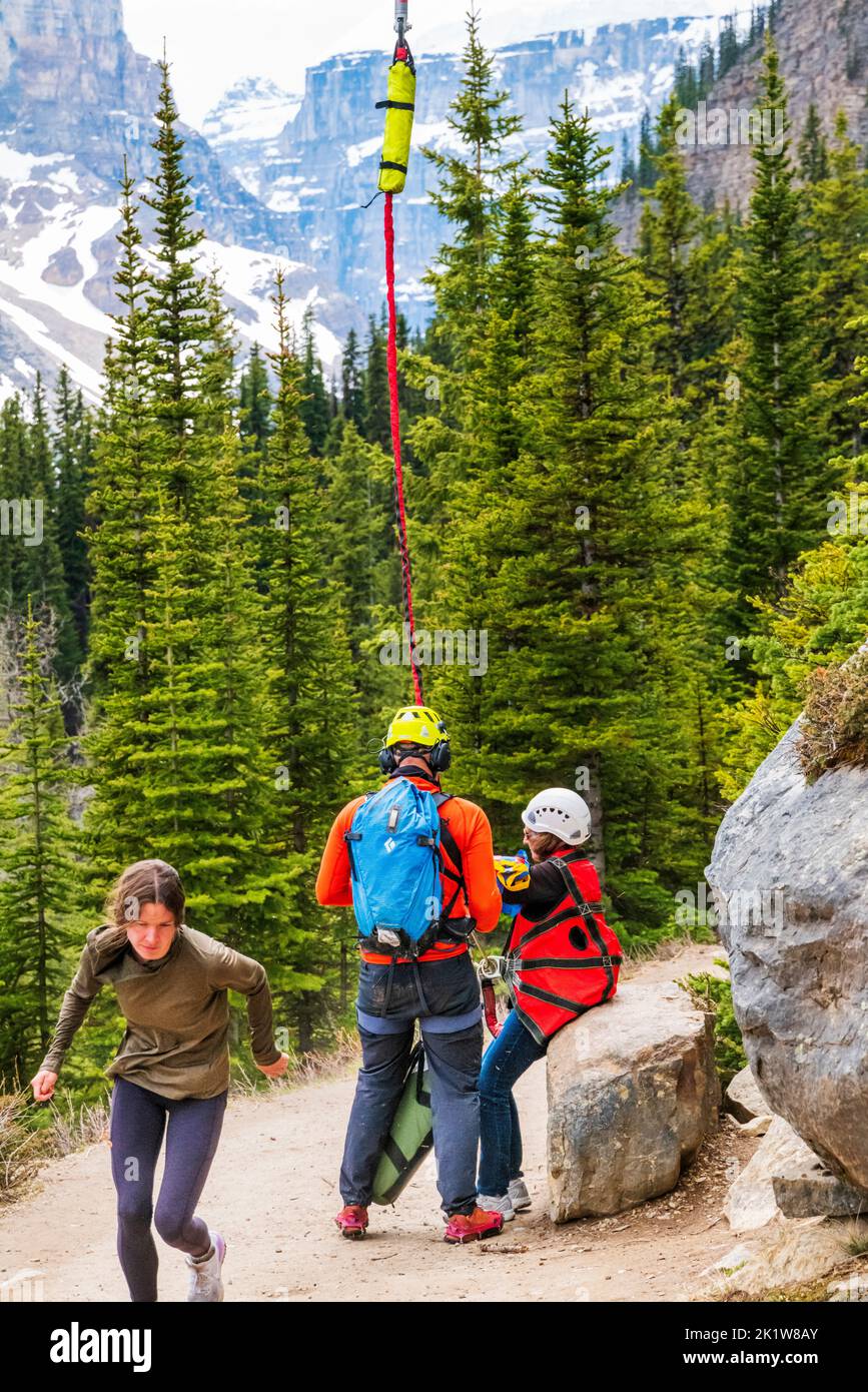 Search & Rescue paramedico evacuando l'escursionista ferito in elicottero; Lago Agnes; Lago Louise; Parco Nazionale di Banff; Alberta; Canada Foto Stock