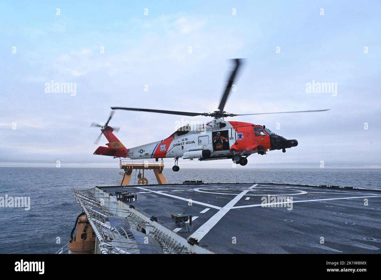 A Coast Guard Air Station Kodiak MH-60 Jayhawk elicottero Aircrew atterra sul ponte della Guardia Costiera statunitense Cutter Healy (WAGB 20) durante le operazioni di volo a Kotzebue Sound, 7 settembre 2022. Queste opportunità di formazione rafforzano l'interoperabilità delle manovre e delle comunicazioni tra le due unità e mantengono le qualifiche degli equipaggi (U.S. Foto della Guardia Costiera di Deborah Heldt Cordone, specialista degli Affari pubblici ausiliari 1) Foto Stock