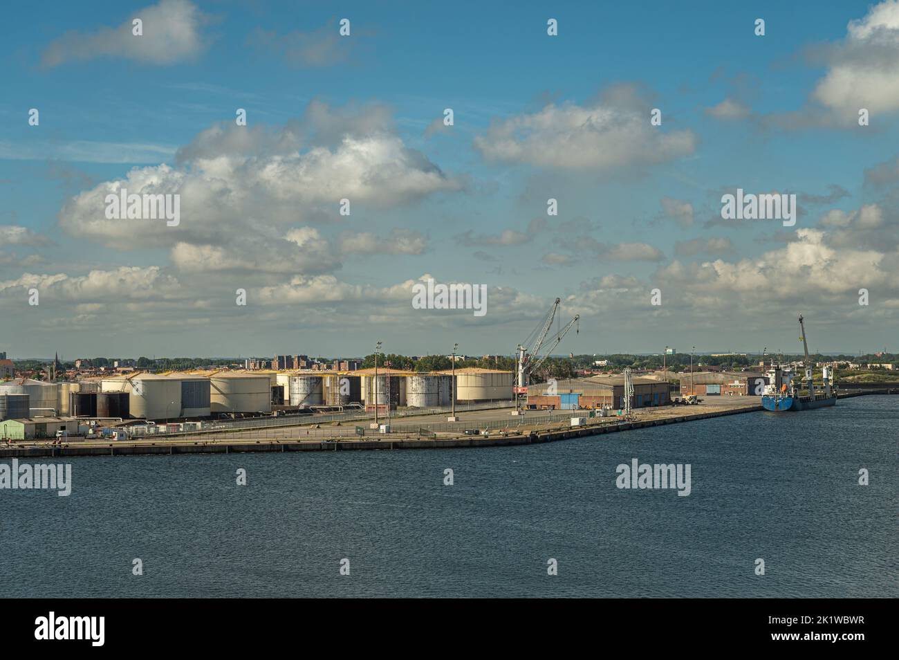 Europa, Francia, Dunkerque - 9 luglio 2022: Scenario del porto. Collezione di enormi carri armati al terminal Rubis e alla banchina sotto il paesaggio azzurro. Vista dall'interno ha Foto Stock
