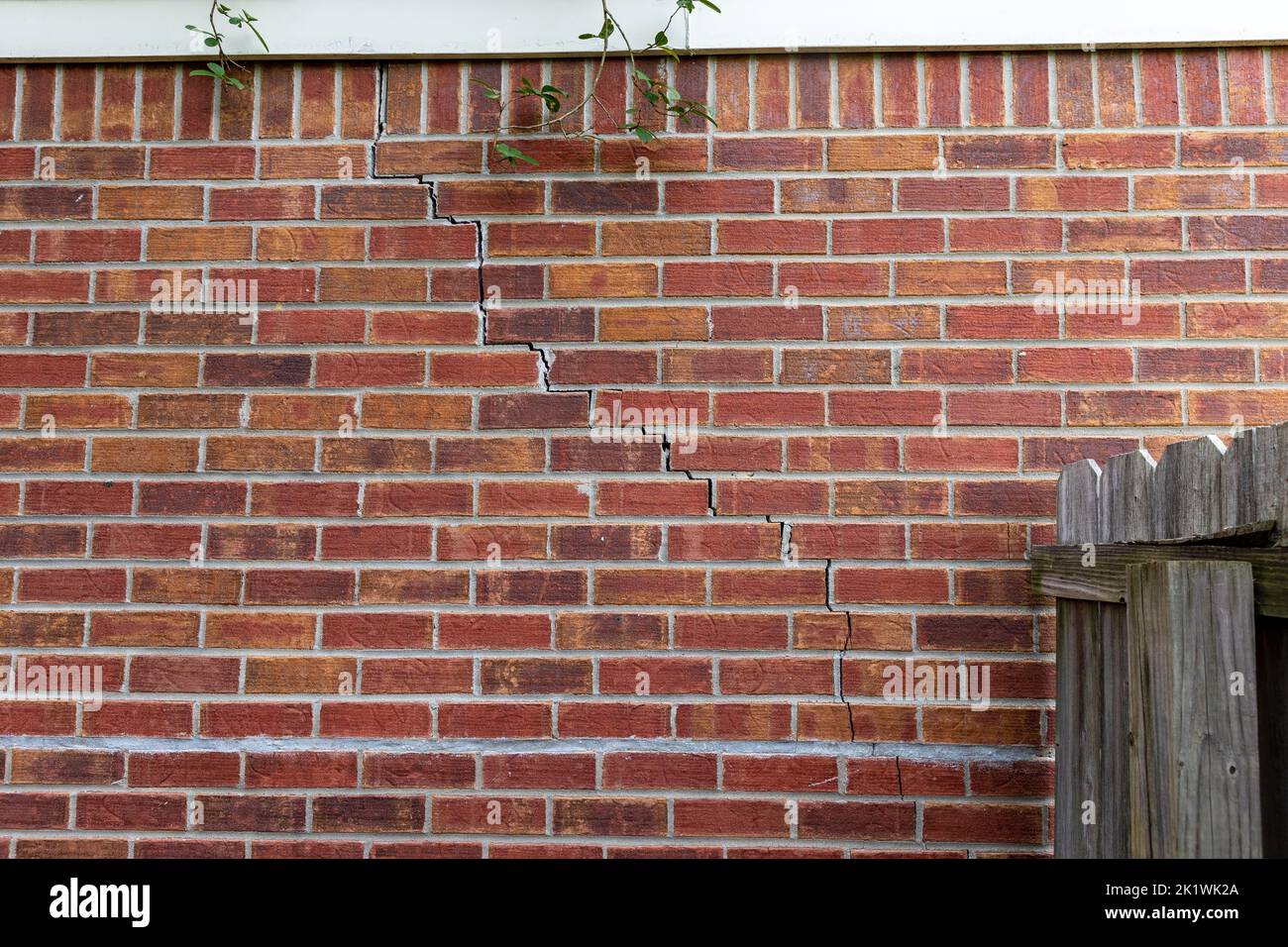 Crack in mattoni di casa da problemi di fondazione Foto Stock