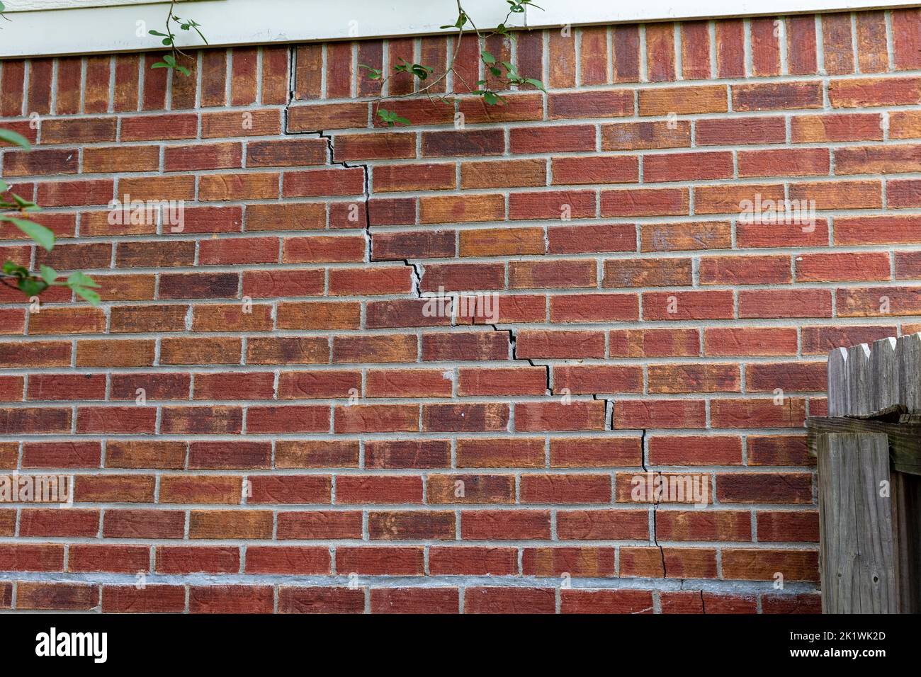 Muro di mattoni di una casa con crepa. Foto Stock