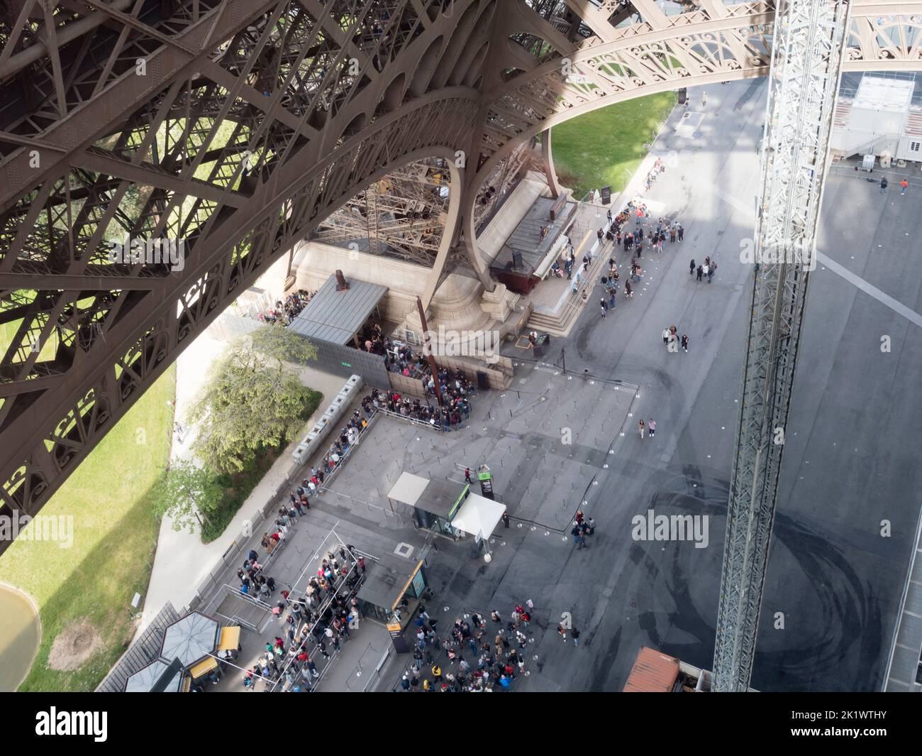 Le persone fanno la fila sotto la Torre Eiffel di Parigi per salire alla piattaforma di osservazione Foto Stock