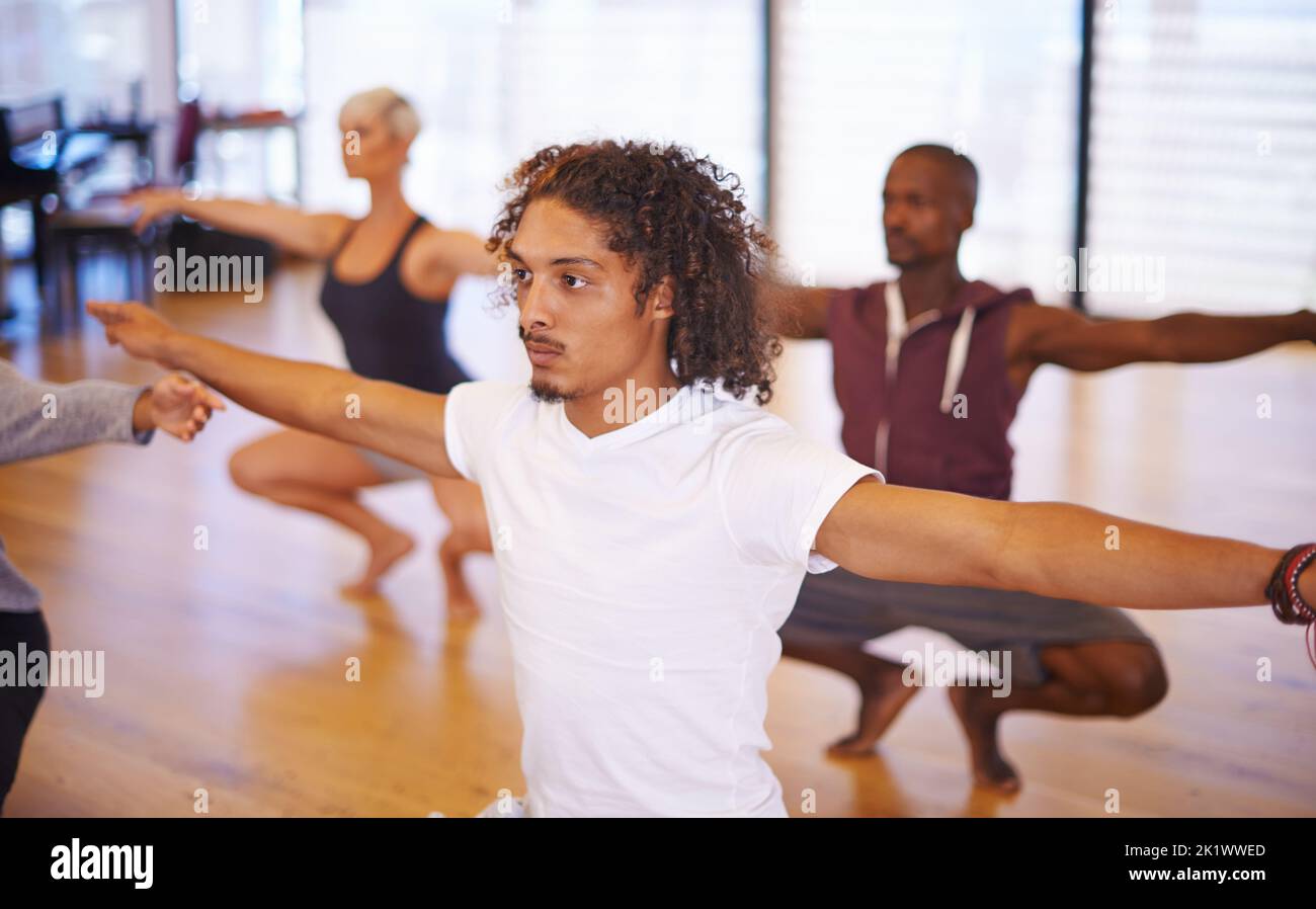 Tenendosi in forma e flessibile, un gruppo di giovani ballerini che squattano in una sala da ballo. Foto Stock