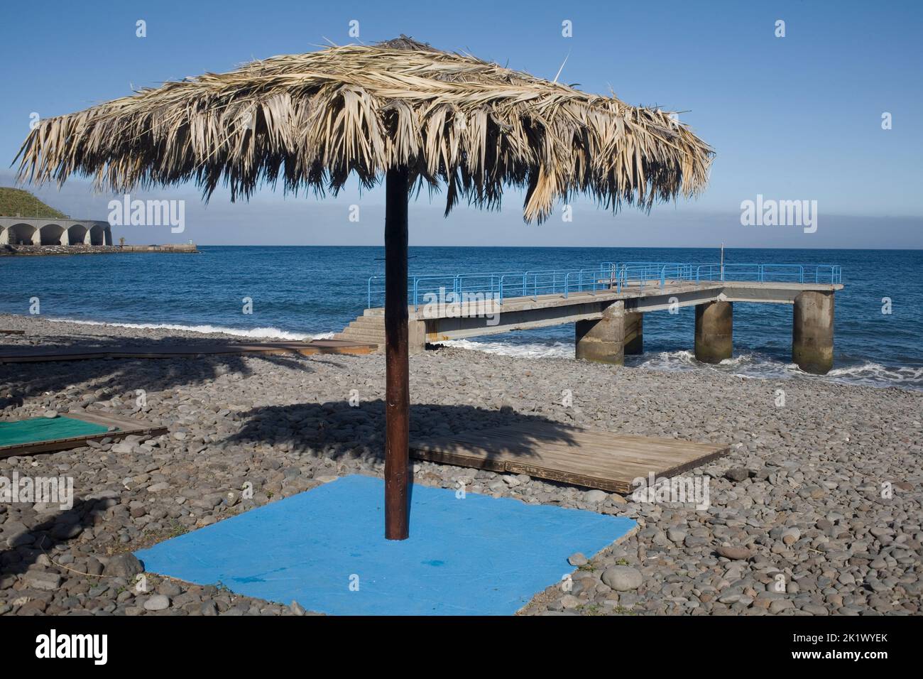 Spiaggia di Palmeiras a Santa Cruz nel sud-est di Madeira con un ombrellone che ha delle foglie per la sua baldacchino Foto Stock