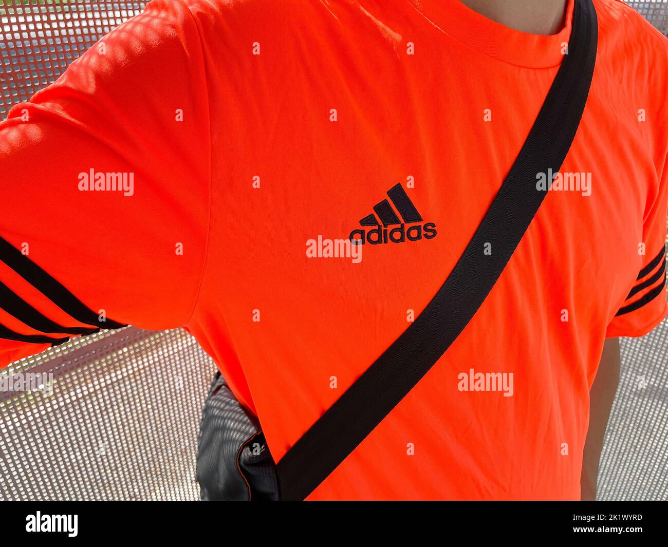 Tyumen, Russia-30 agosto 2022: Logo Adidas su una T-shirt arancione. Adidas è una multinazionale tedesca per la produzione di abbigliamento e piede Foto Stock