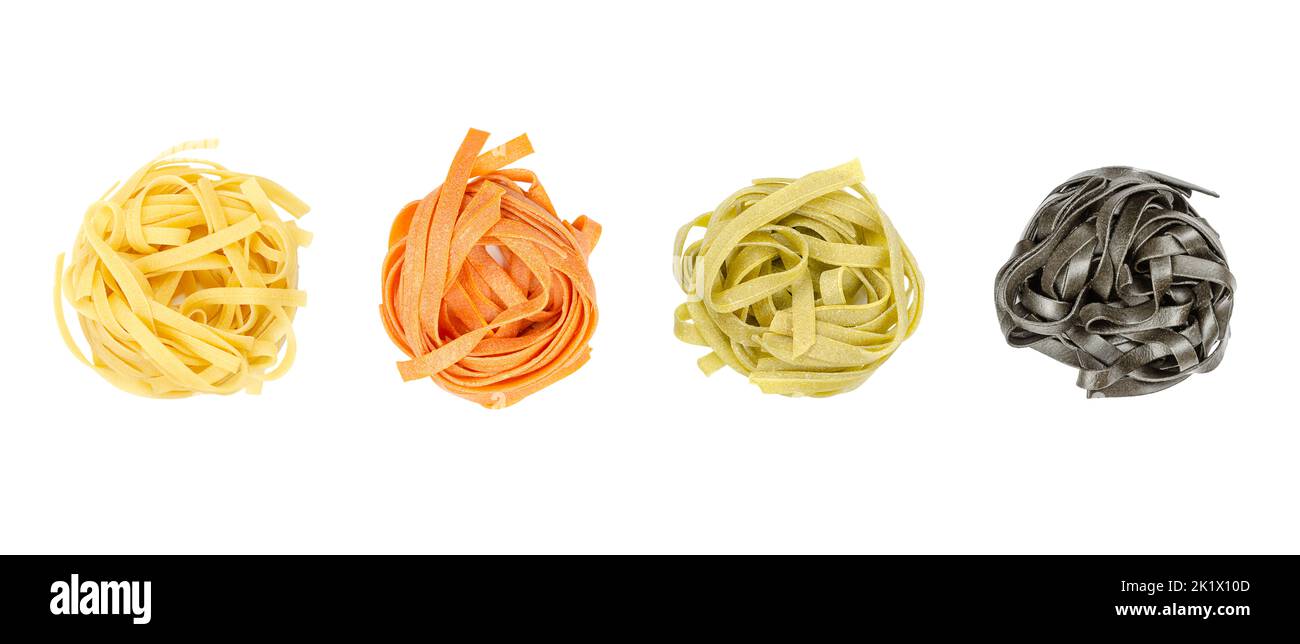 Tagliatelle di diversi colori, intrecciate in nidi, dall'alto, isolate, sopra bianche. Pasta all'uovo tradizionale italiana cruda e secca. Foto Stock