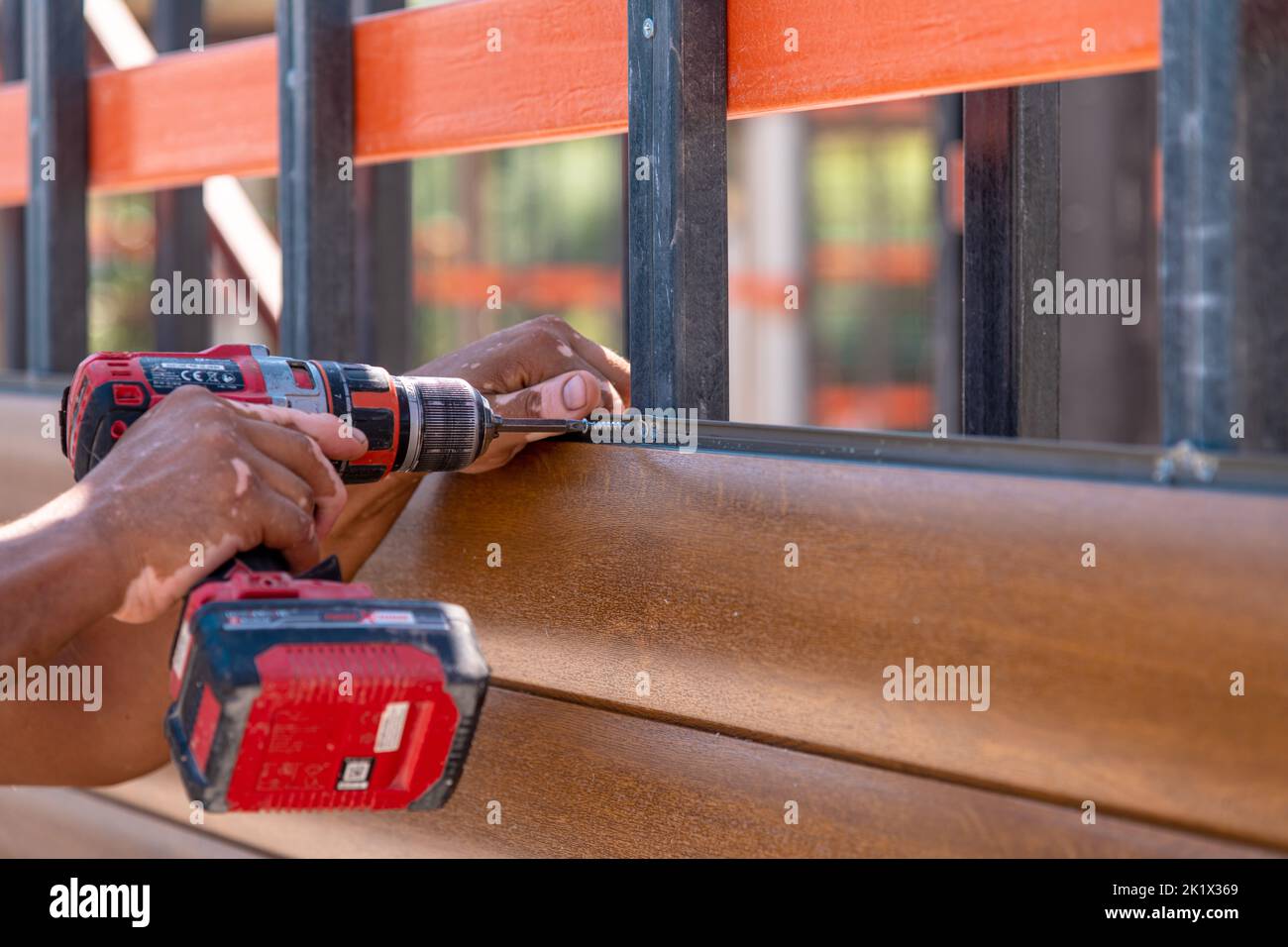 Uomo che monta pareti composite utilizzando un avvitatore a batteria Foto Stock