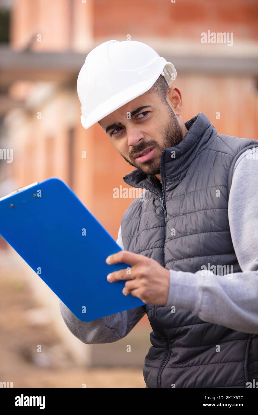 lavoratore di costruzione maschile all'aperto scrivere su appunti Foto Stock