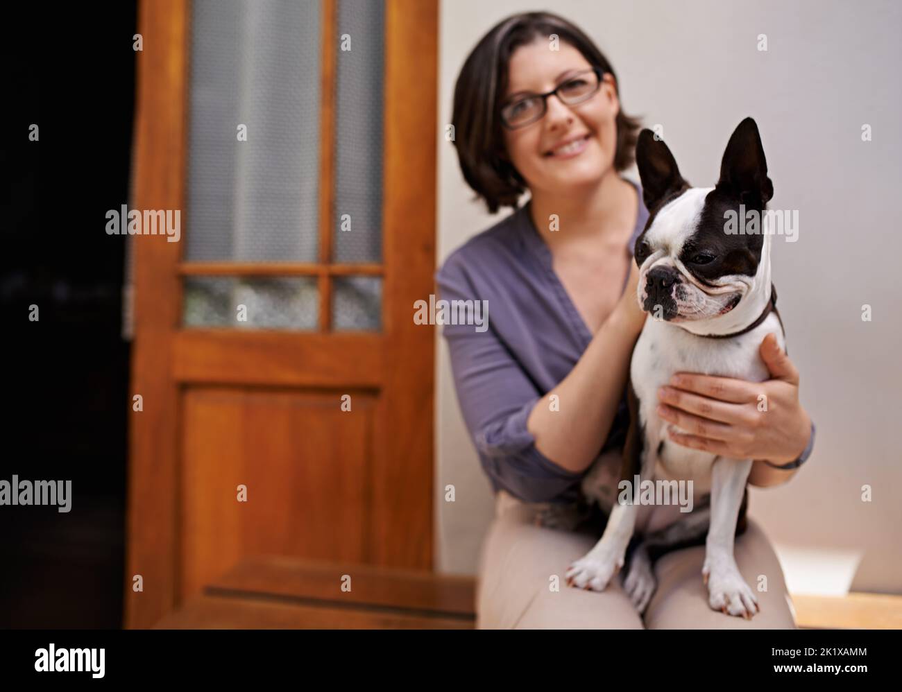 L'amore è una parola a quattro zampe. Un ritratto di donna di mezza età seduta su una panchina fuori casa con il suo cane. Foto Stock