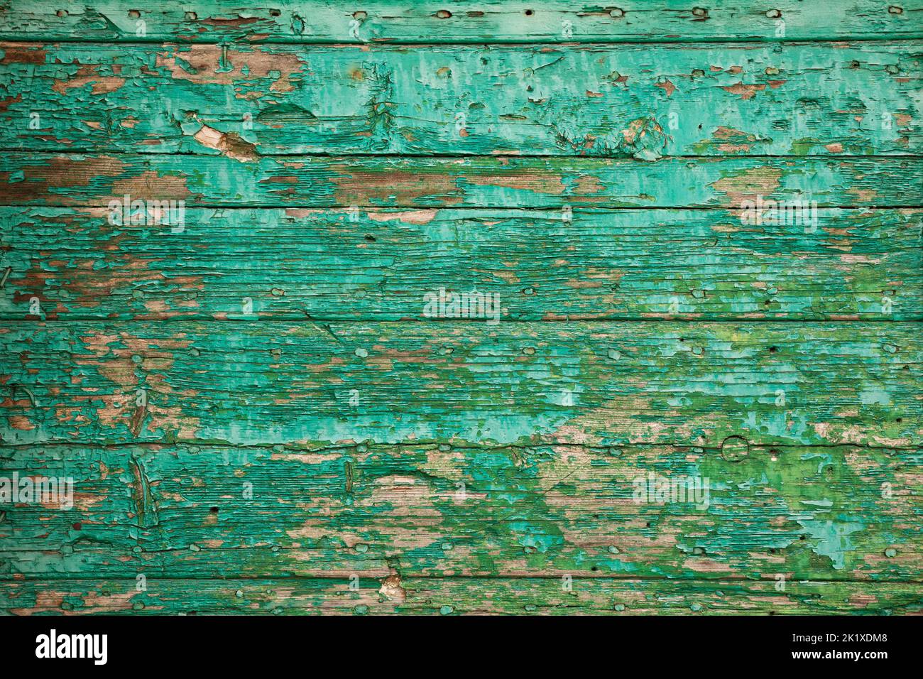 Vecchio asse di legno con vernice di peeling. Texture sfondo di vernice verde fiocco su tavola spaccata di legno Foto Stock