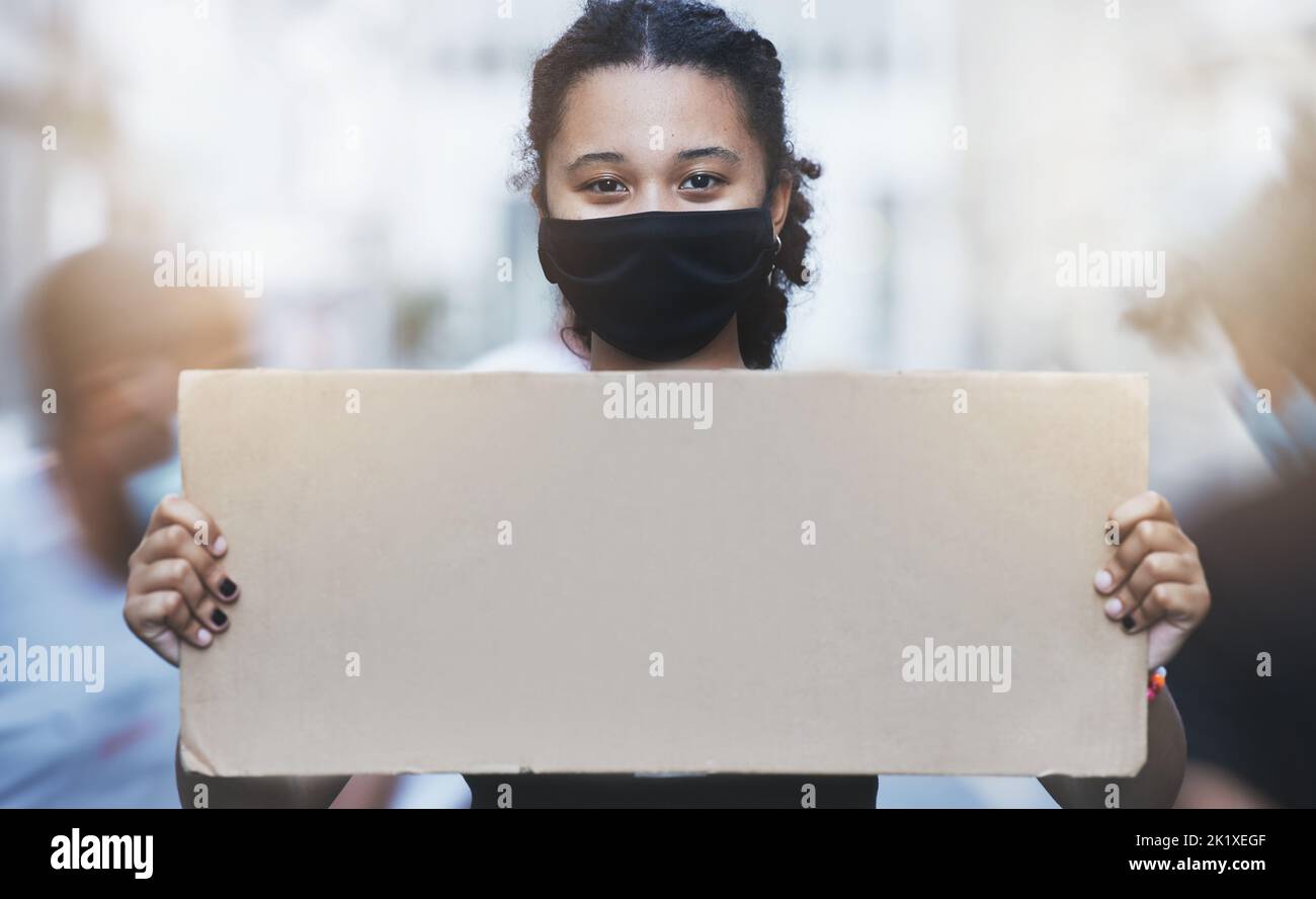 Attivismo, protesta e ragazza con un poster con spazio copia in una strada con maschera facciale durante la pandemia. Ritratto dell'attivista per i diritti umani che protestava con Foto Stock