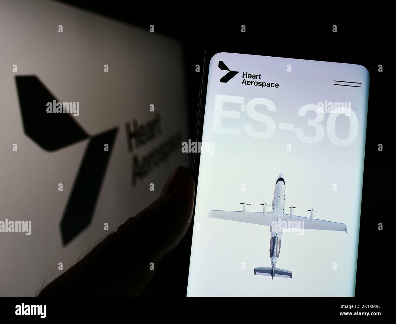 Persona che tiene il cellulare con la pagina web della società svedese Heart Aerospace AB sullo schermo di fronte al logo. Messa a fuoco al centro del display del telefono. Foto Stock