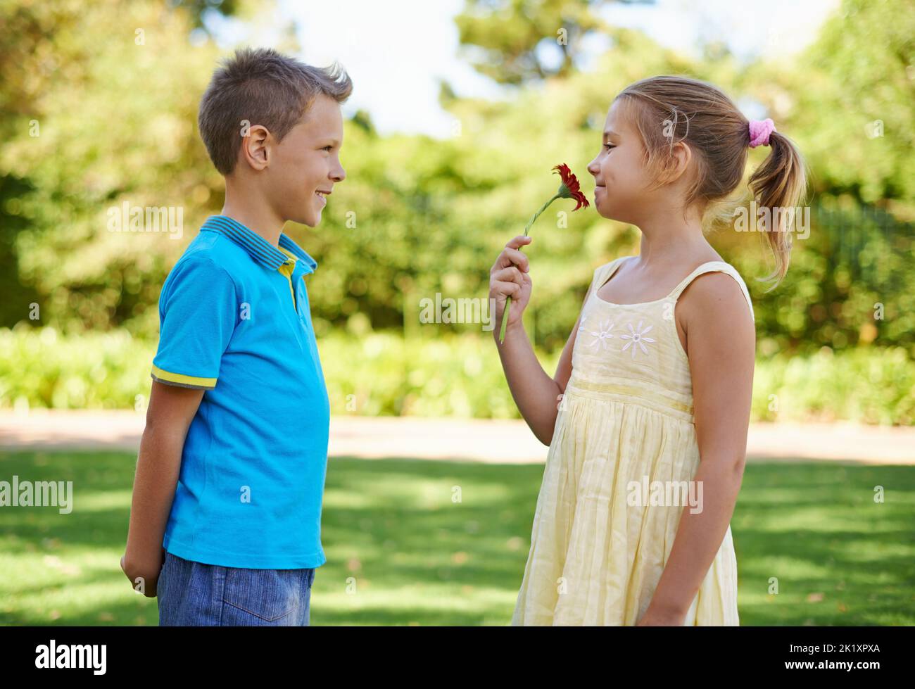 La cavalleria non è morta. Una bambina che tiene felice il fiore dato a lei da un ragazzo carino con una cotta. Foto Stock