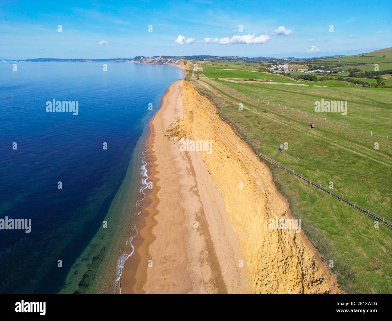 Vista dall'aria delle scogliere di arenaria dorata presso la spiaggia di alveare a Burton Bradstock sulla costa del Dorset Jurassic in una calda giornata autunnale soleggiata. Foto Stock