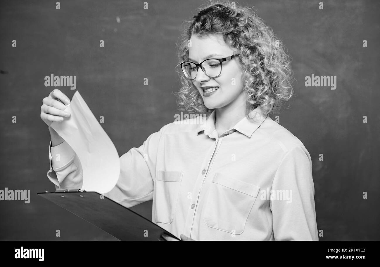Leggere l'impressing RESUME. Il tutor controlla le esercitazioni. Saggio preventivo dei richiedenti. Progetto scolastico. L'insegnante di letteratura legge la composizione. Donna signora intelligente Foto Stock