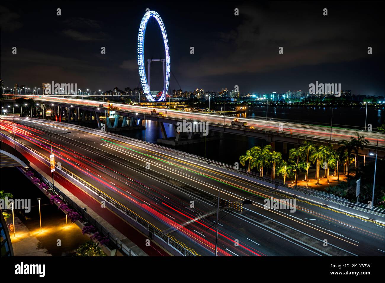 Singapore Flyer di notte con luci auto in autostrada in primo piano. Singapore Foto Stock