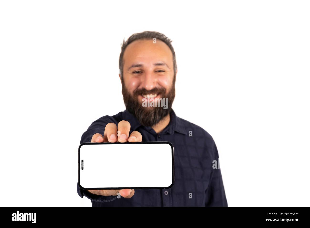Tenendo in mano smartphone, felice sorridente maschio caucasico tenendo in mano smartphone. Mostrare la moderna simulazione orizzontale del telefono cellulare. Ritratto dell'uomo bearato in piedi. Foto Stock