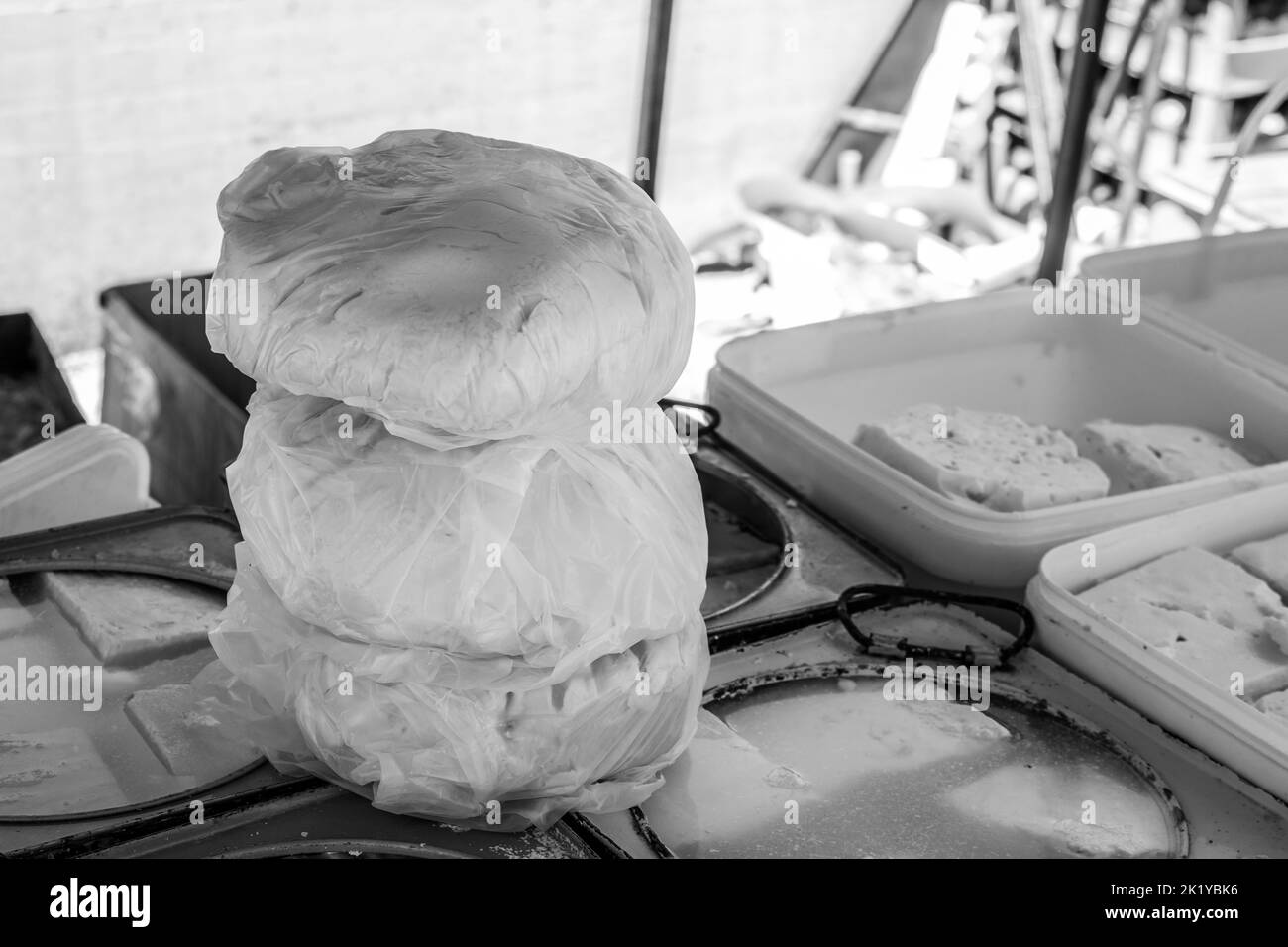 Formaggi e latticini in vendita presso uno stallo nel mercato aperto della città di Tetovo nel nord della Macedonia. Articoli freschi in vendita in contenitori e scatole. Foto Stock