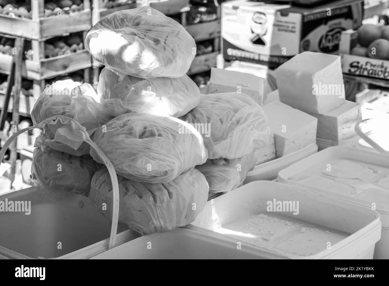 Formaggi e latticini in vendita presso uno stallo nel mercato aperto della città di Tetovo nel nord della Macedonia. Articoli freschi in vendita in contenitori e scatole. Foto Stock