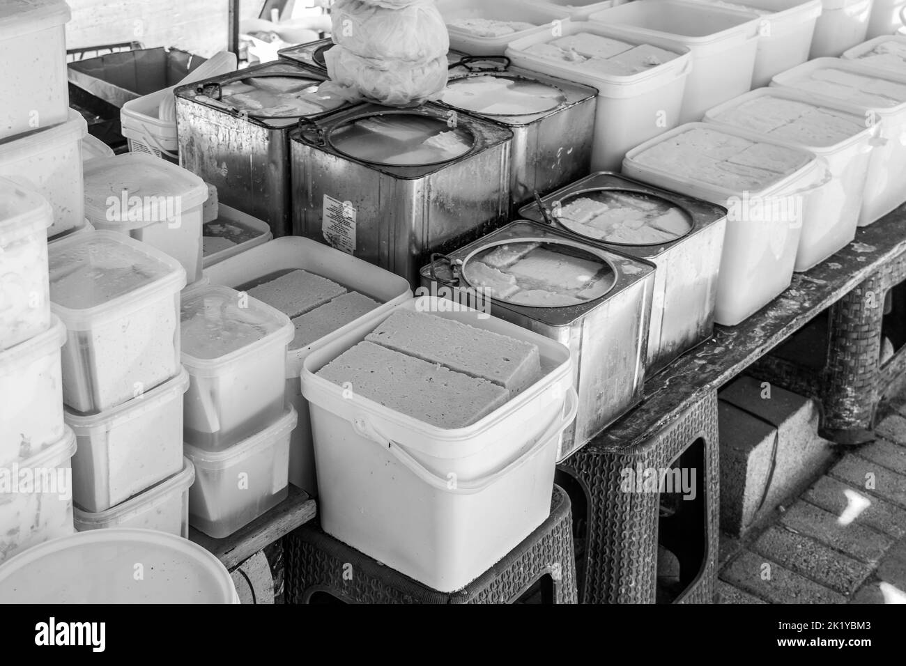 Formaggi e latticini in vendita presso uno stallo nel mercato aperto della città di Tetovo nel nord della Macedonia. Articoli freschi in vendita in contenitori e scatole. Foto Stock