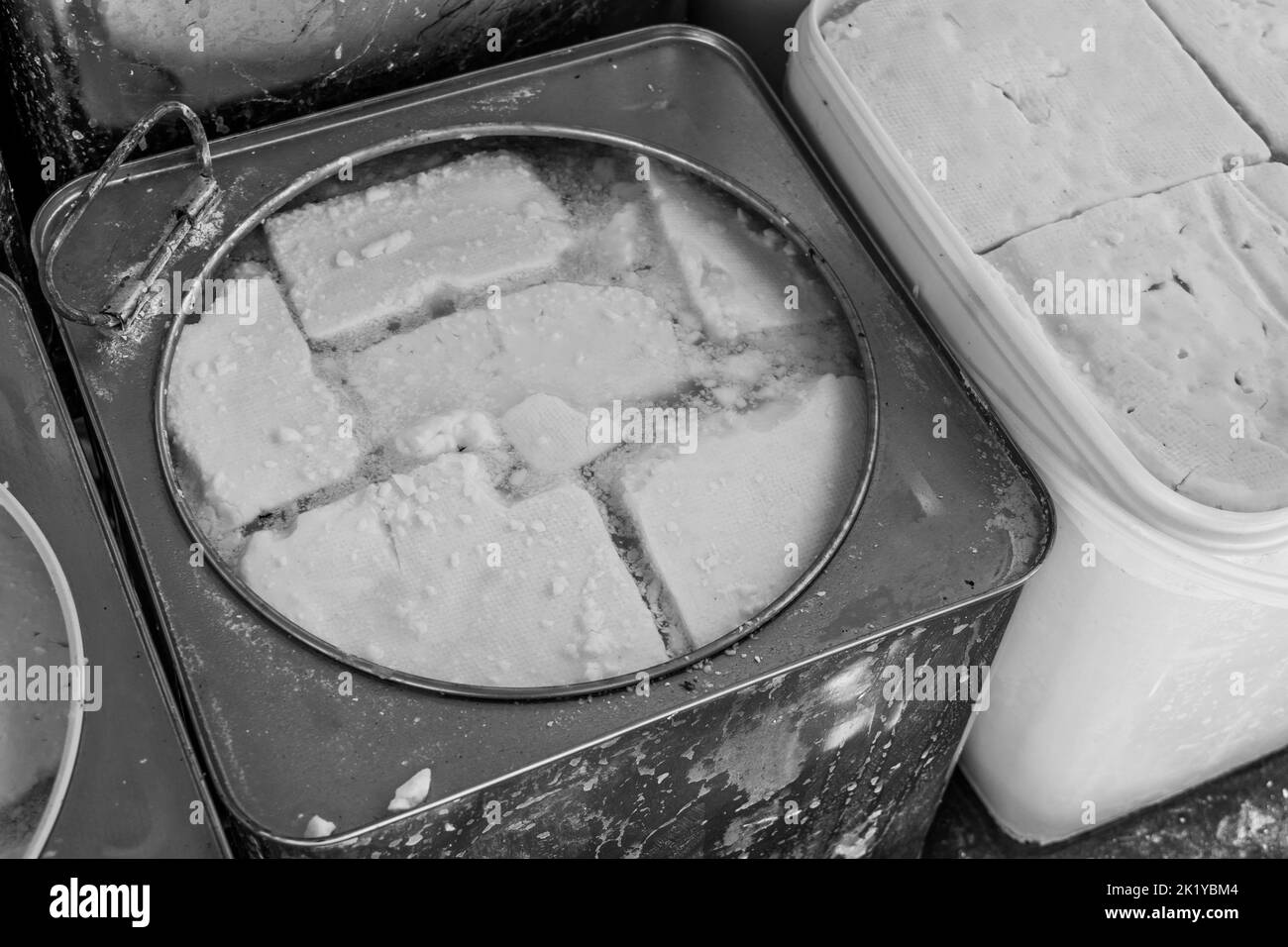 Formaggi e latticini in vendita presso uno stallo nel mercato aperto della città di Tetovo nel nord della Macedonia. Articoli freschi in vendita in contenitori e scatole. Foto Stock