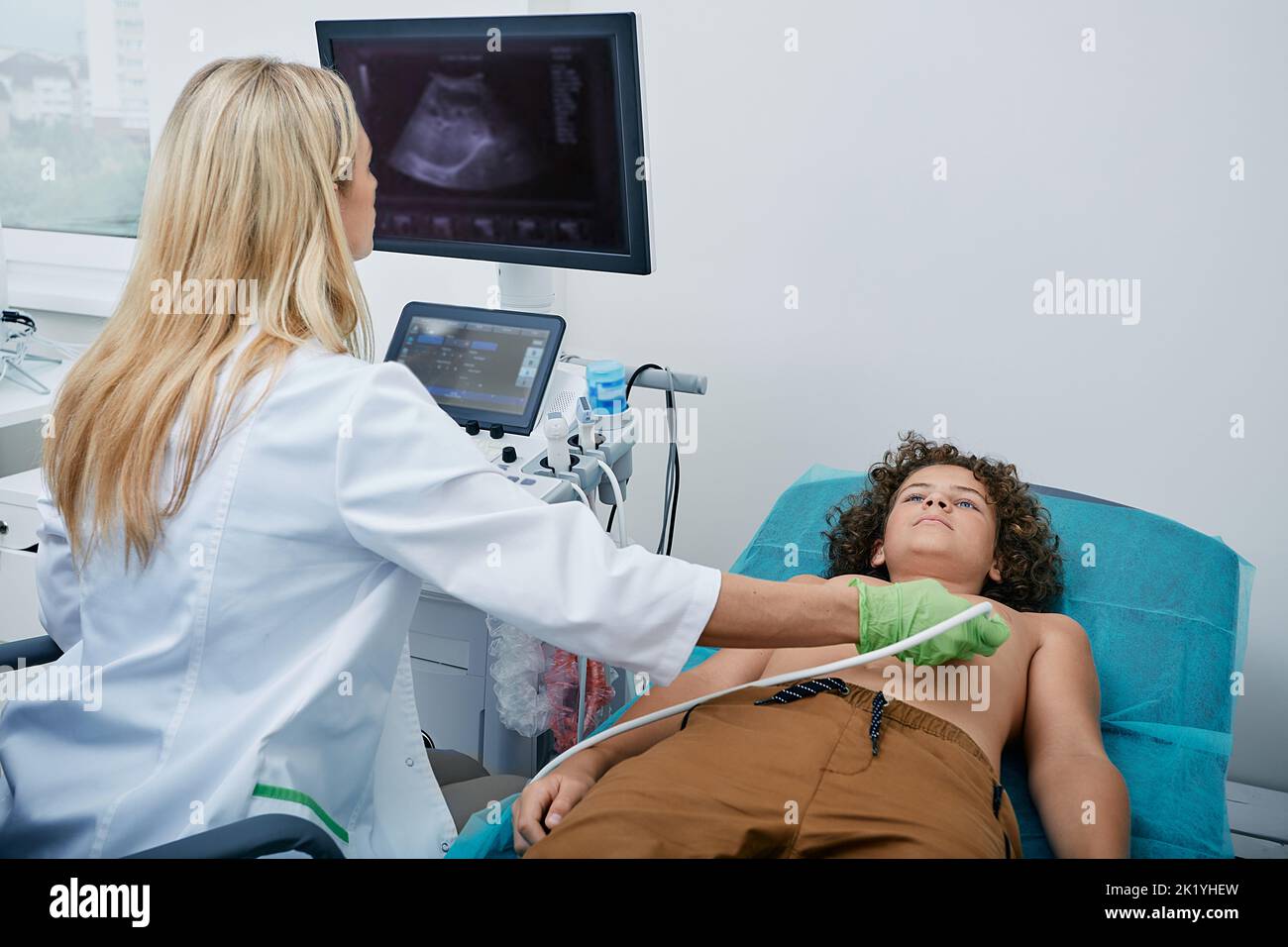 Esame ecografico del cuore per il bambino di sesso maschile con specialista di ecografia mentre esame medico in ospedale Foto Stock