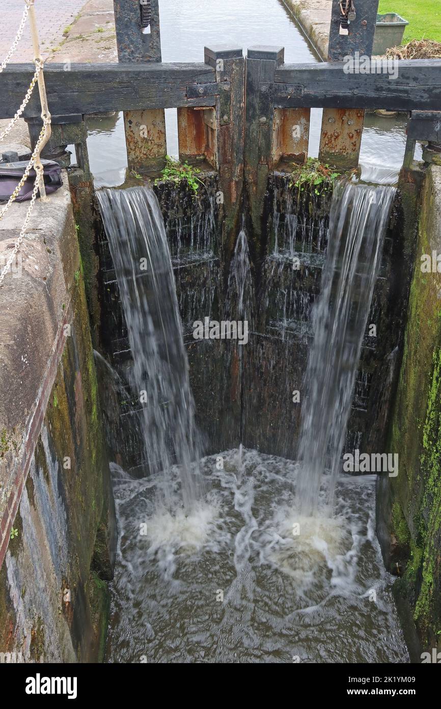Cancelli di chiusura del canale con acqua in eccesso che scorre sopra, Ellesmere Port, Cheshire, Inghilterra, Regno Unito Foto Stock