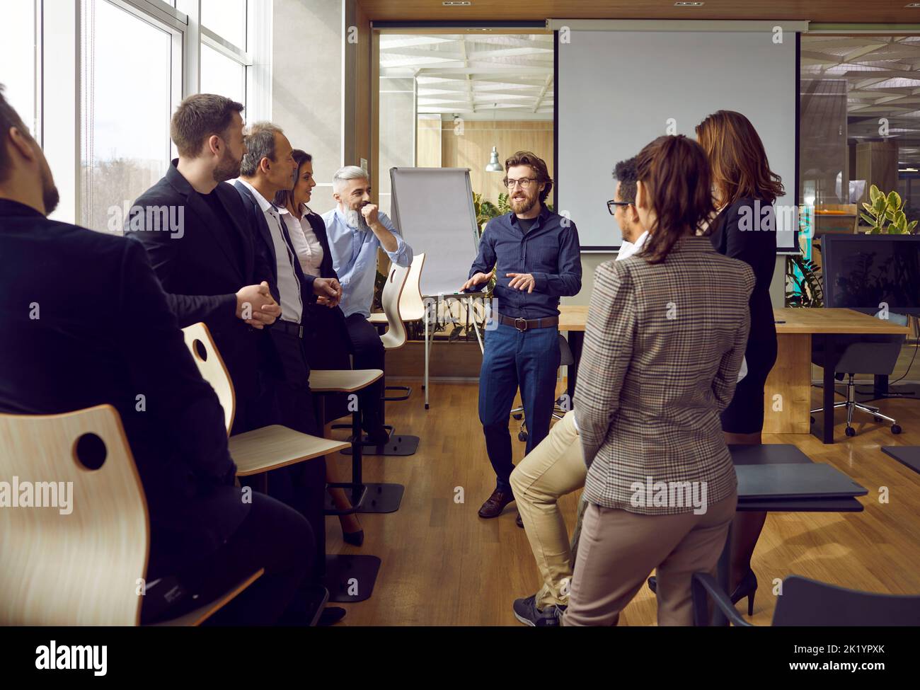 Un uomo d'affari conduce riunioni informali con diversi dipendenti Foto Stock