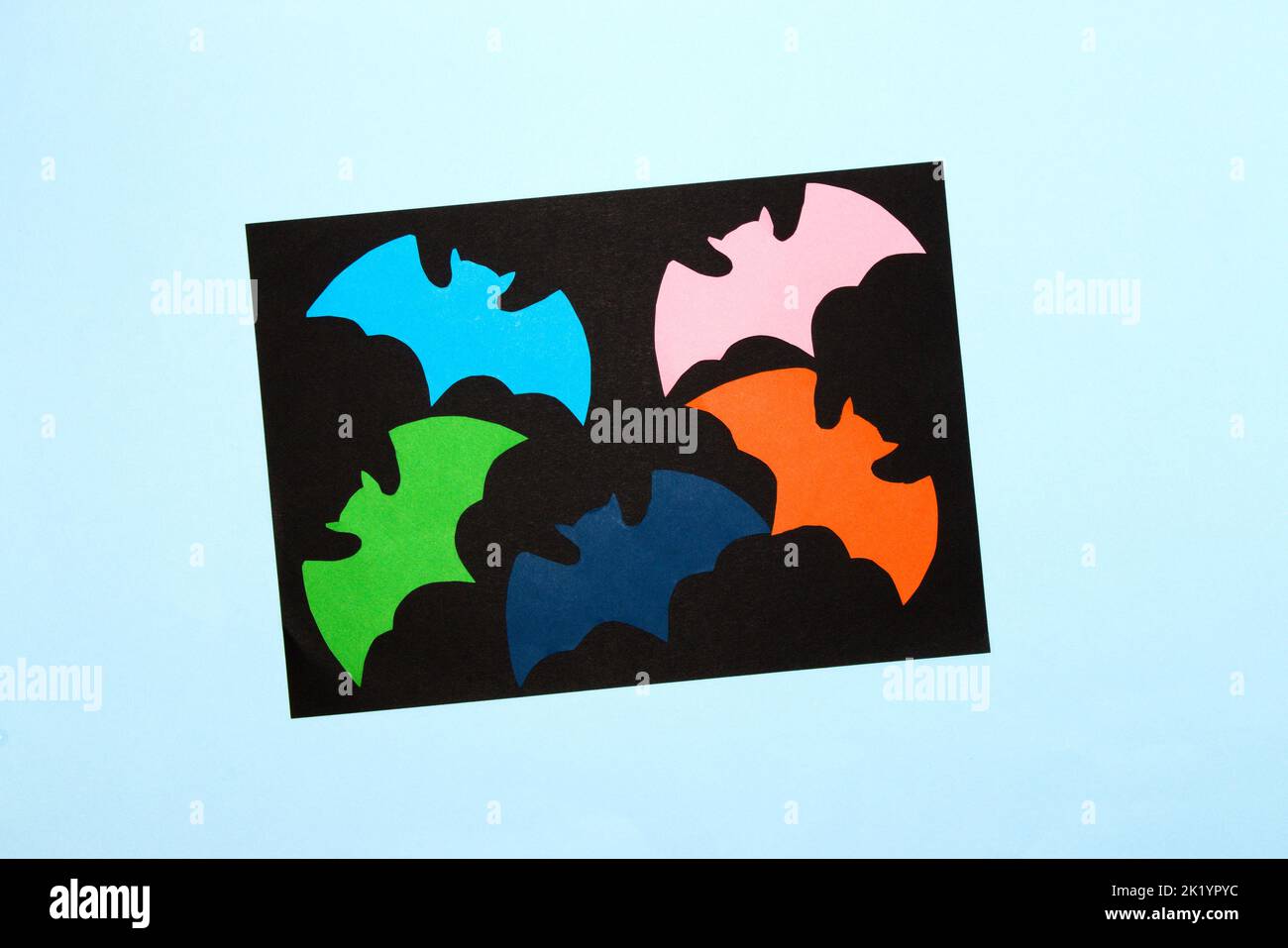 pipistrelli colorati sulla parte nera dello sfondo, intorno al nero è lo sfondo blu, arte creativa halloween design, carta artigianale, piatto Foto Stock