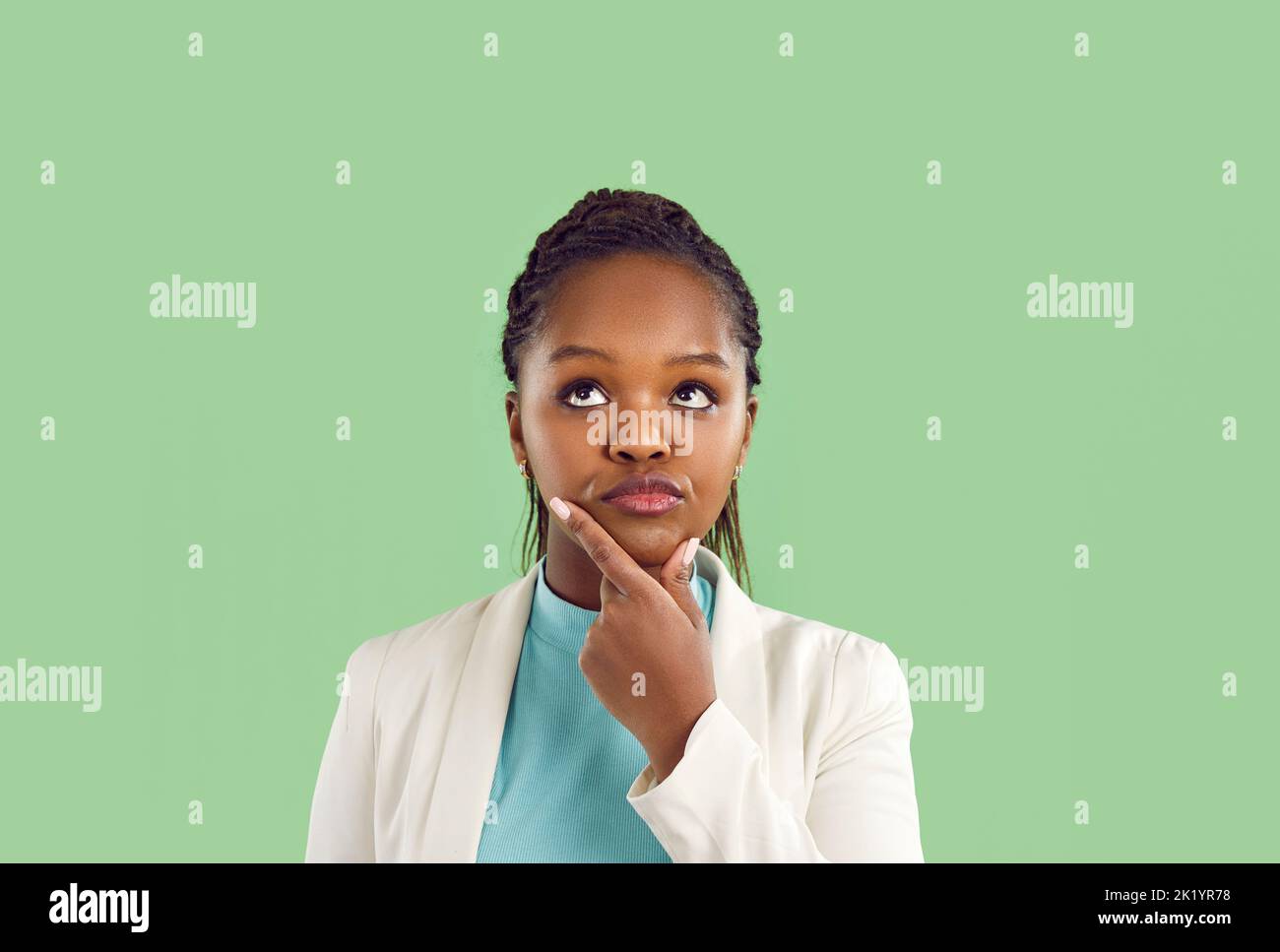 Ritratto di donna pensata pensare e prendere decisioni isolato su sfondo verde chiaro. Foto Stock