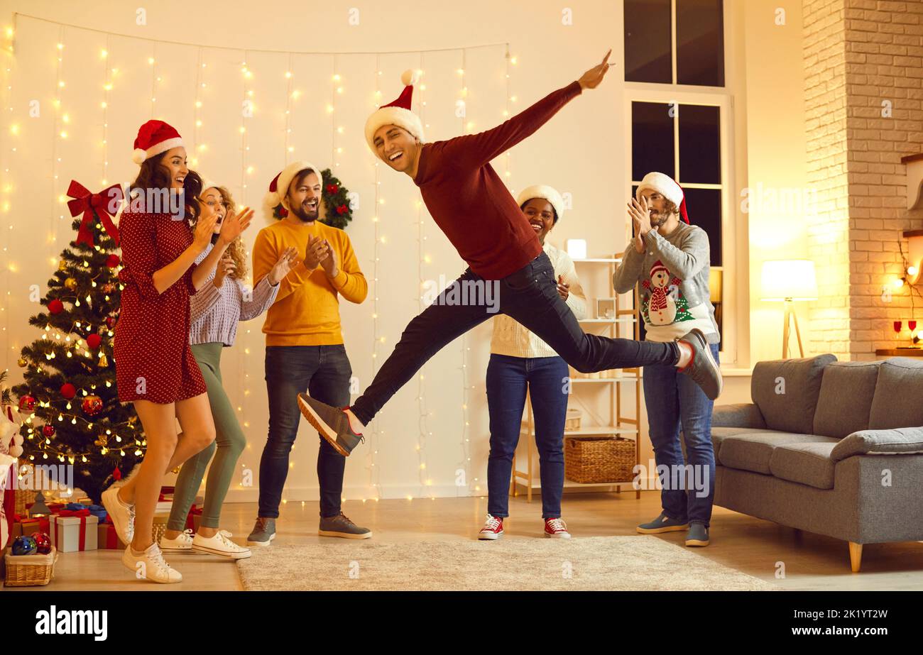 Amici diversi e felici festeggiano il Natale insieme Foto Stock
