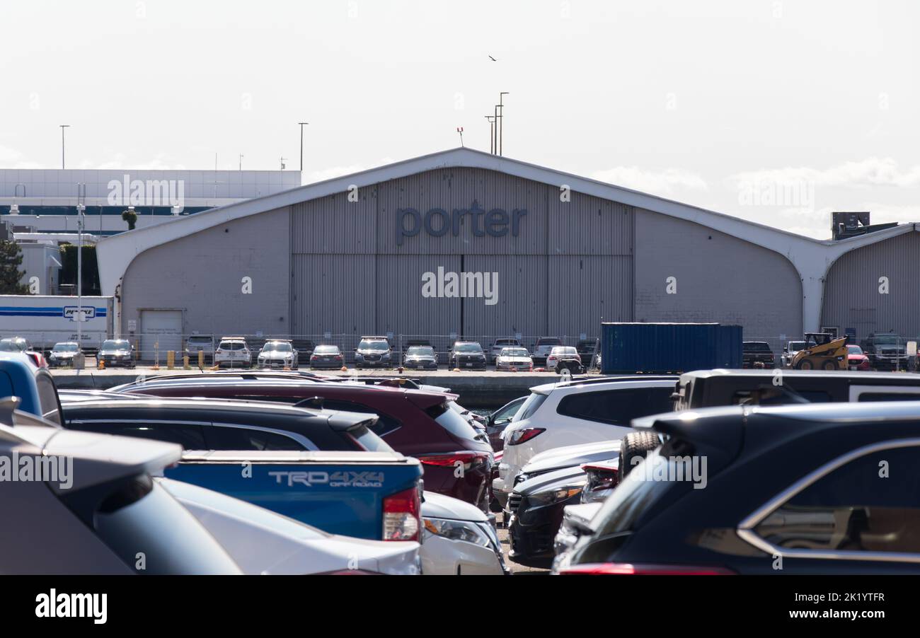 Un portellino della Porter Airlines è visto all'aeroporto di Toronto Island, di fronte alle file di auto parcheggiate al parcheggio dell'aeroporto in una giornata nuvolosa. Foto Stock