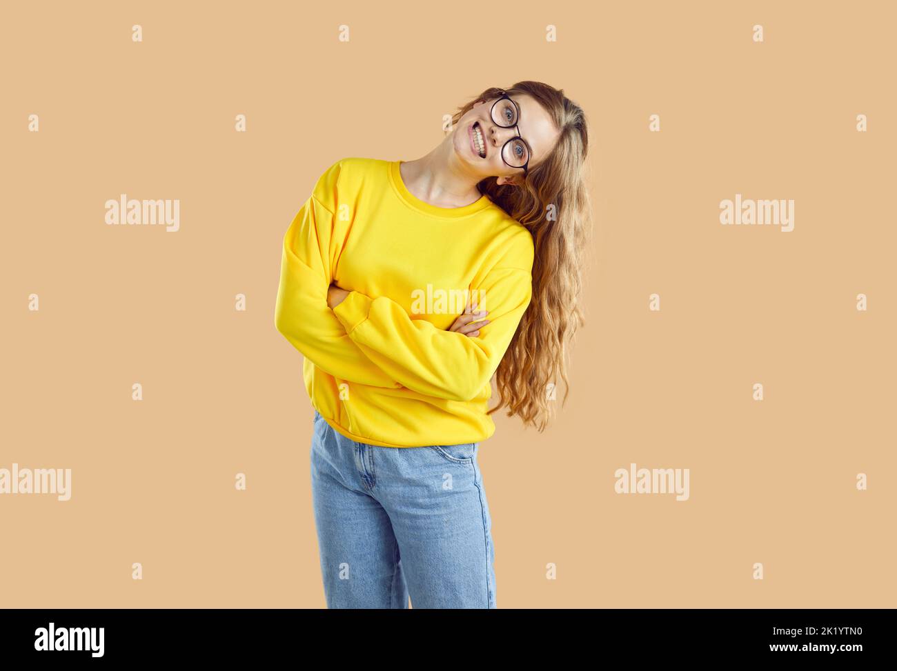 Ritratto di ragazza allegra e goofy con ampio sorriso divertente e pazzo su sfondo beige chiaro. Foto Stock