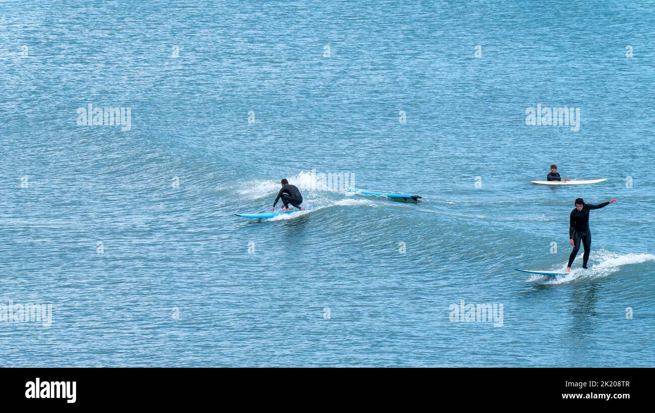 West Cork, Irlanda, 12 giugno 2022. Tre uomini in abiti impermeabili sono surf. Uomo che naviga in mare Foto Stock