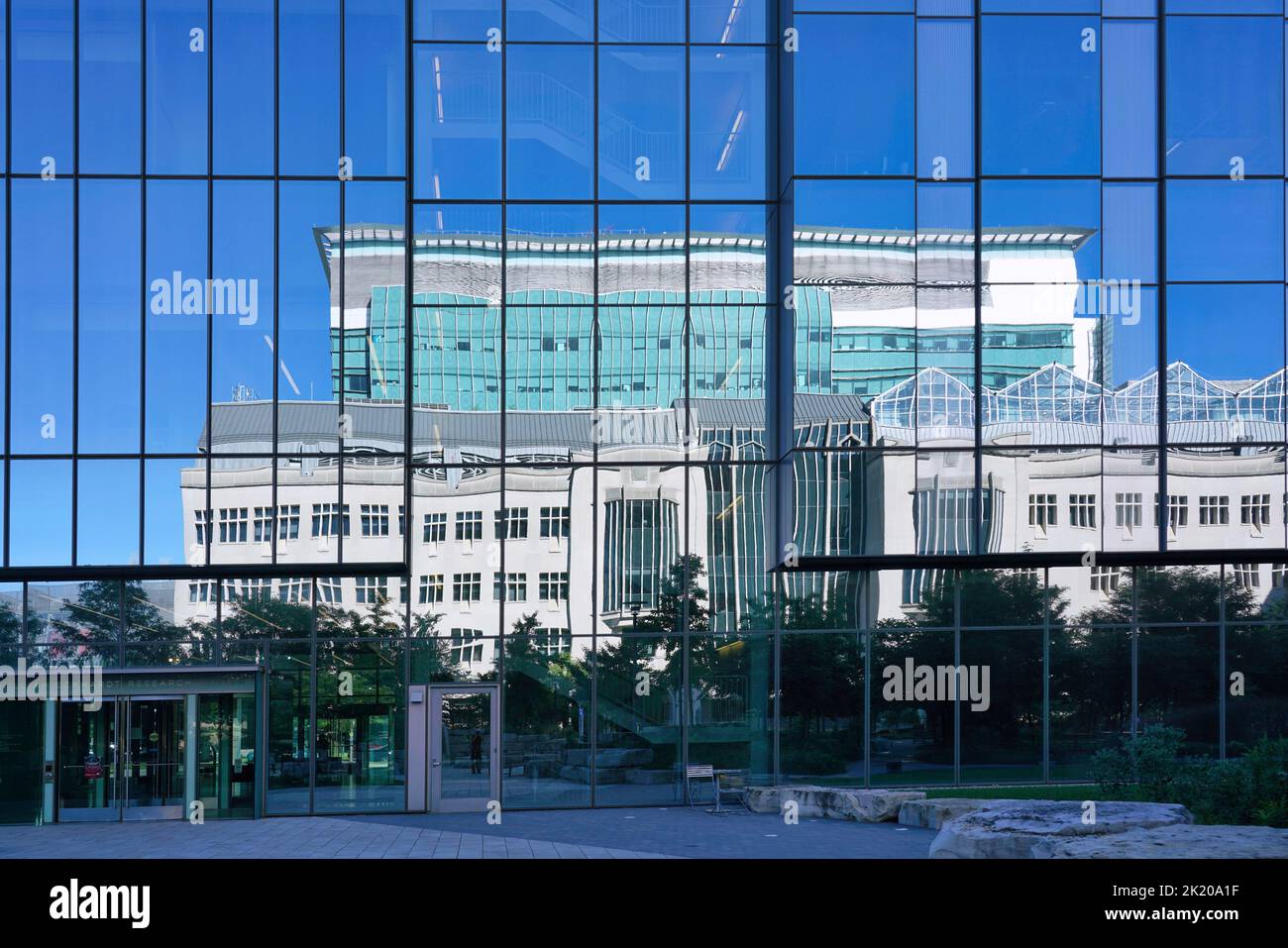 Chicago, USA - Settembre 2022: La Pritzker Medical School dell'Università di Chicago si riflette nella facciata a specchio di una ricerca medica adiacente Foto Stock