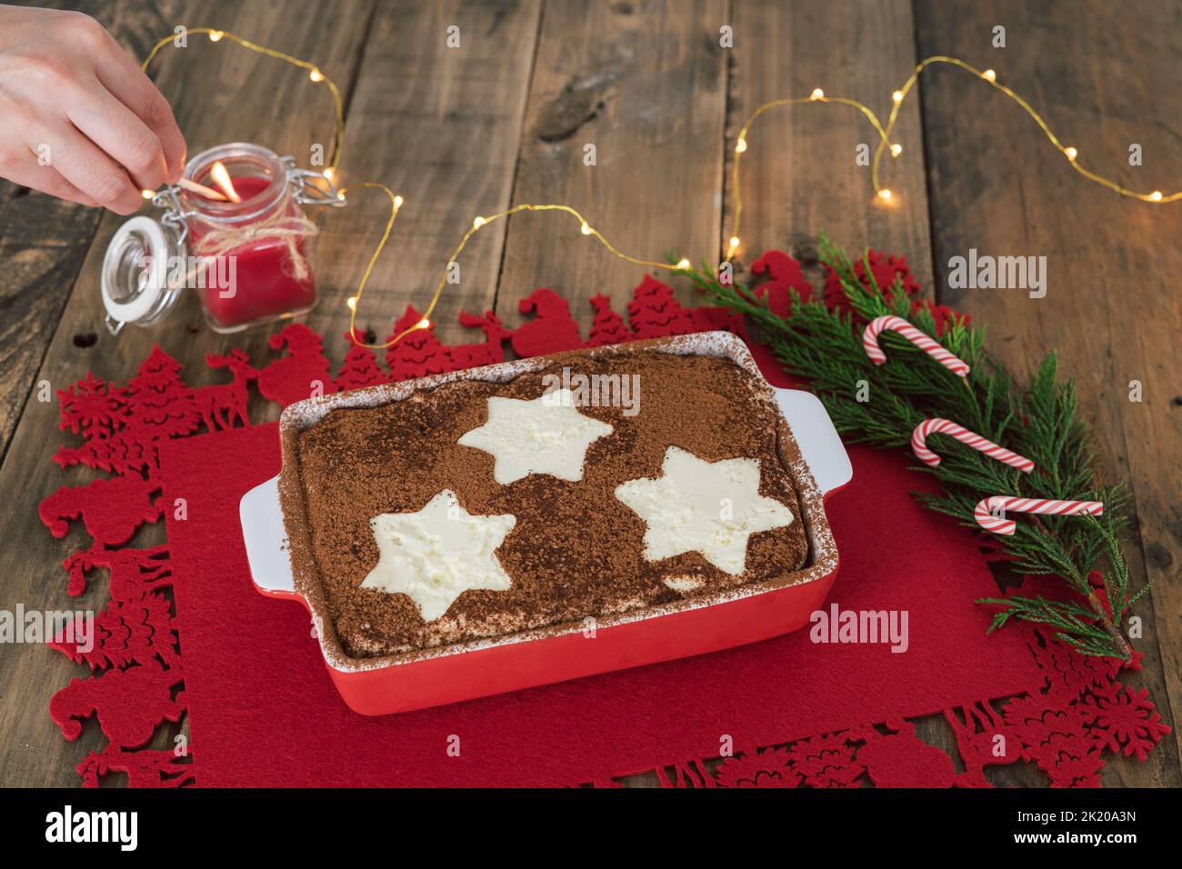 Tiramisù con decorazioni a stelle e ornamenti natalizi su sfondo ligneo. Caramelle di Natale. Spazio di copia. Foto Stock