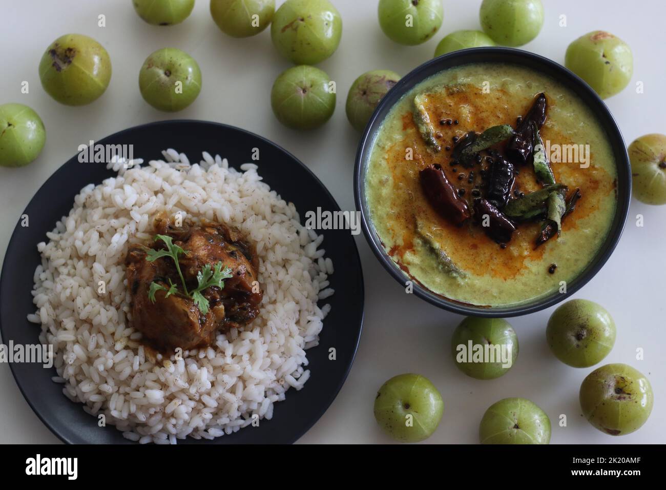 Nellika curry servito con pasto di riso Kerala. Il curry di uva spina di cocco in stile Kerala è fatto di uva spina fresca, cocco macinato e spezie. Scatto su w Foto Stock