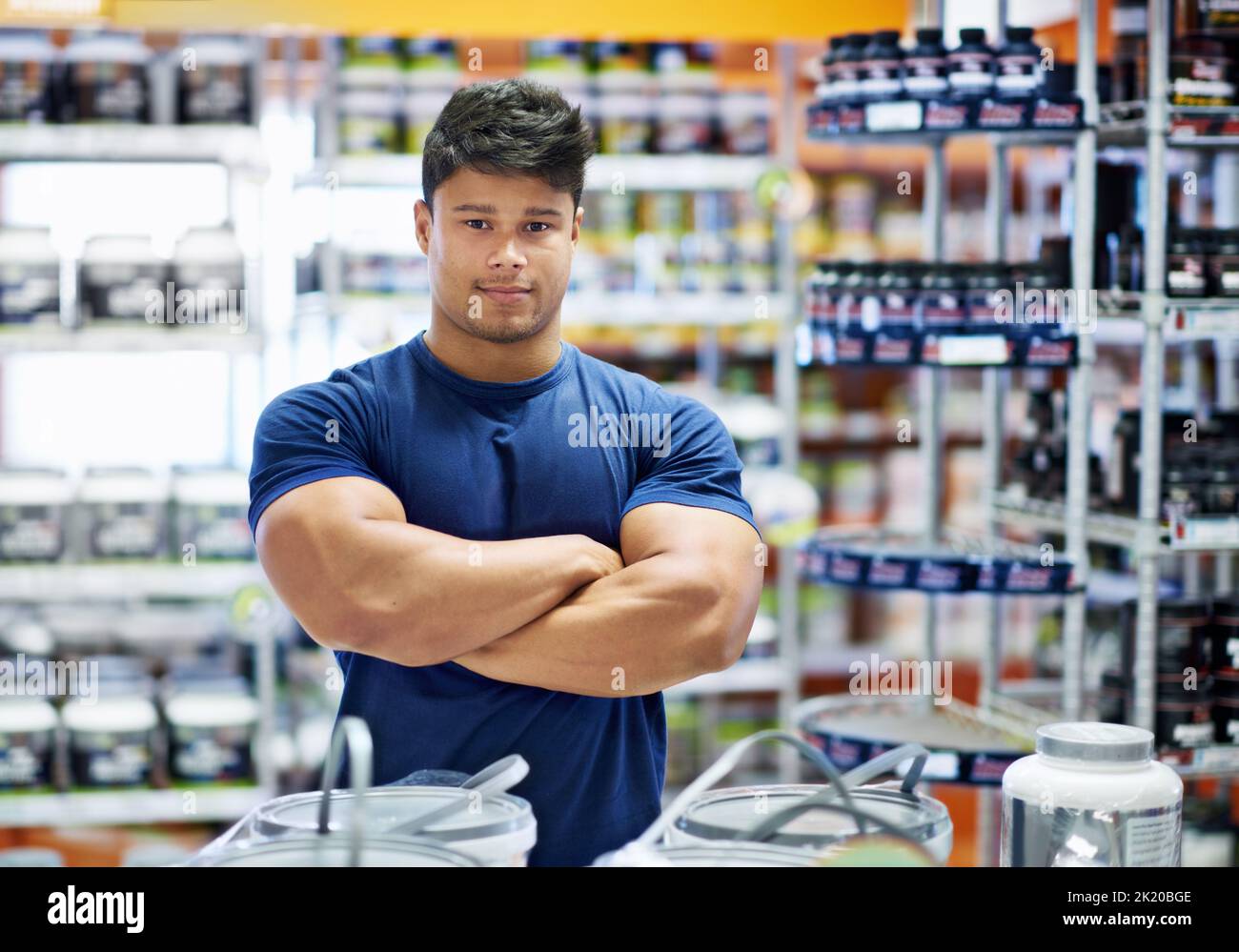 Il mio corpo ha bisogno di energia. Un giovane muscolare nella sezione supplemento di una farmacia. Foto Stock