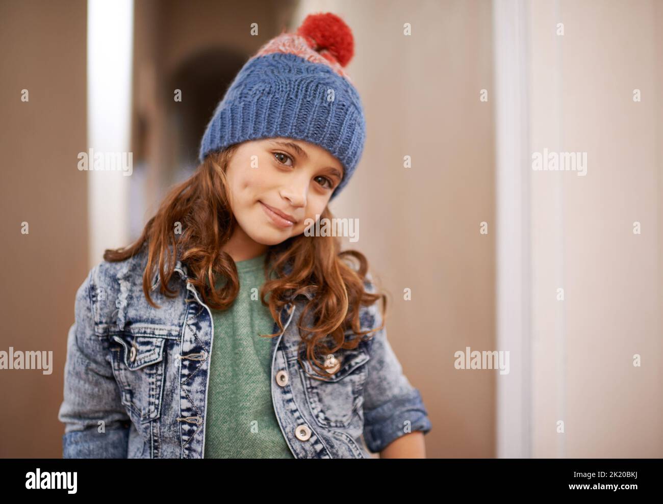 Vestito caldo per l'inverno. Una ragazza giovane cute che posa all'interno. Foto Stock